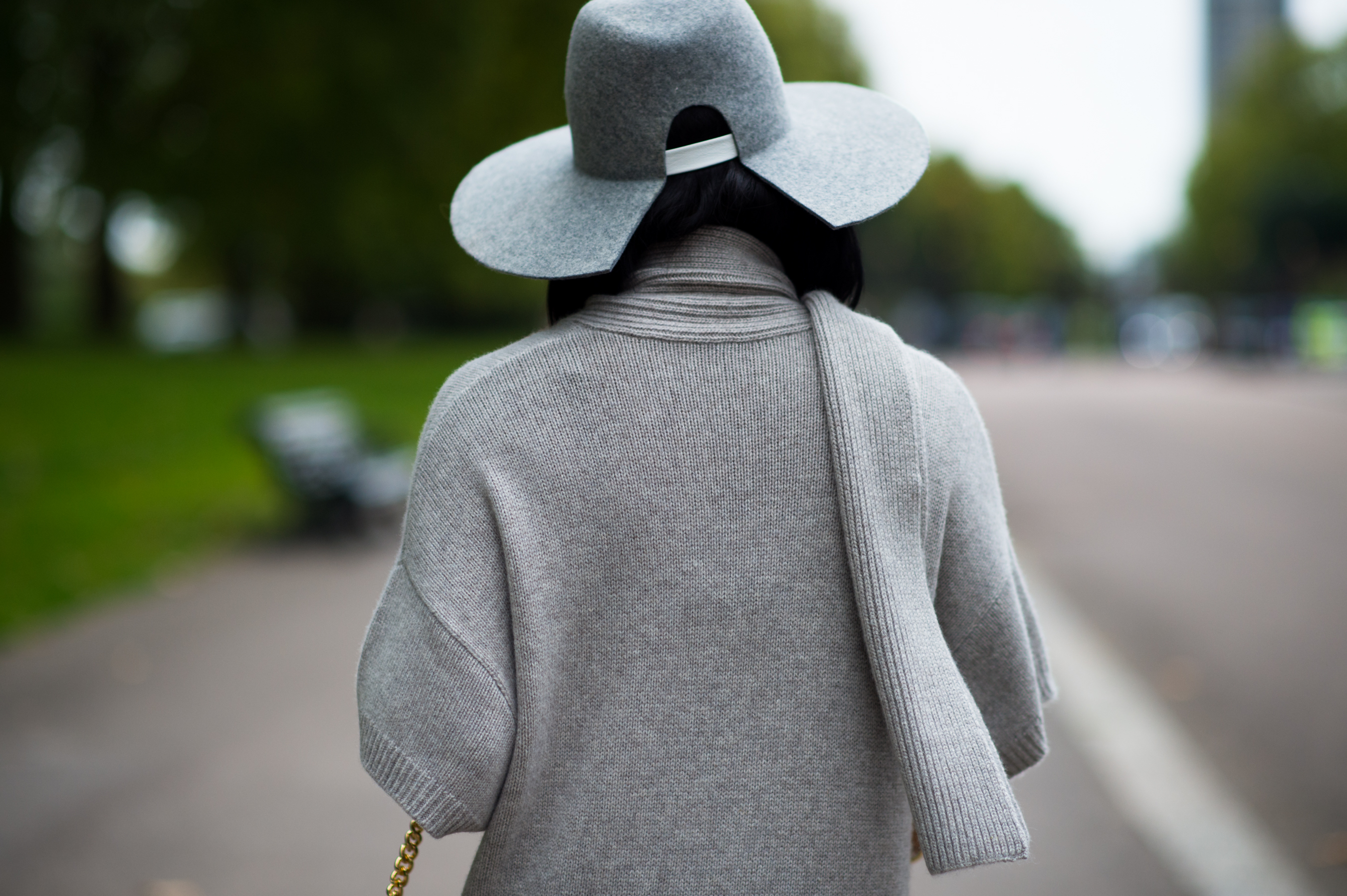 Woman wearing gray hat and knitwear leaving the show
