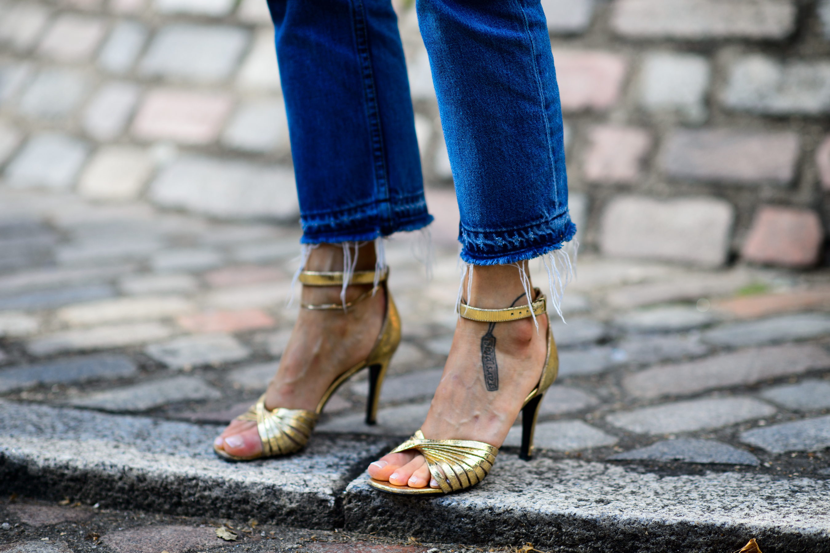 Close up of golden sandals and jeans edge