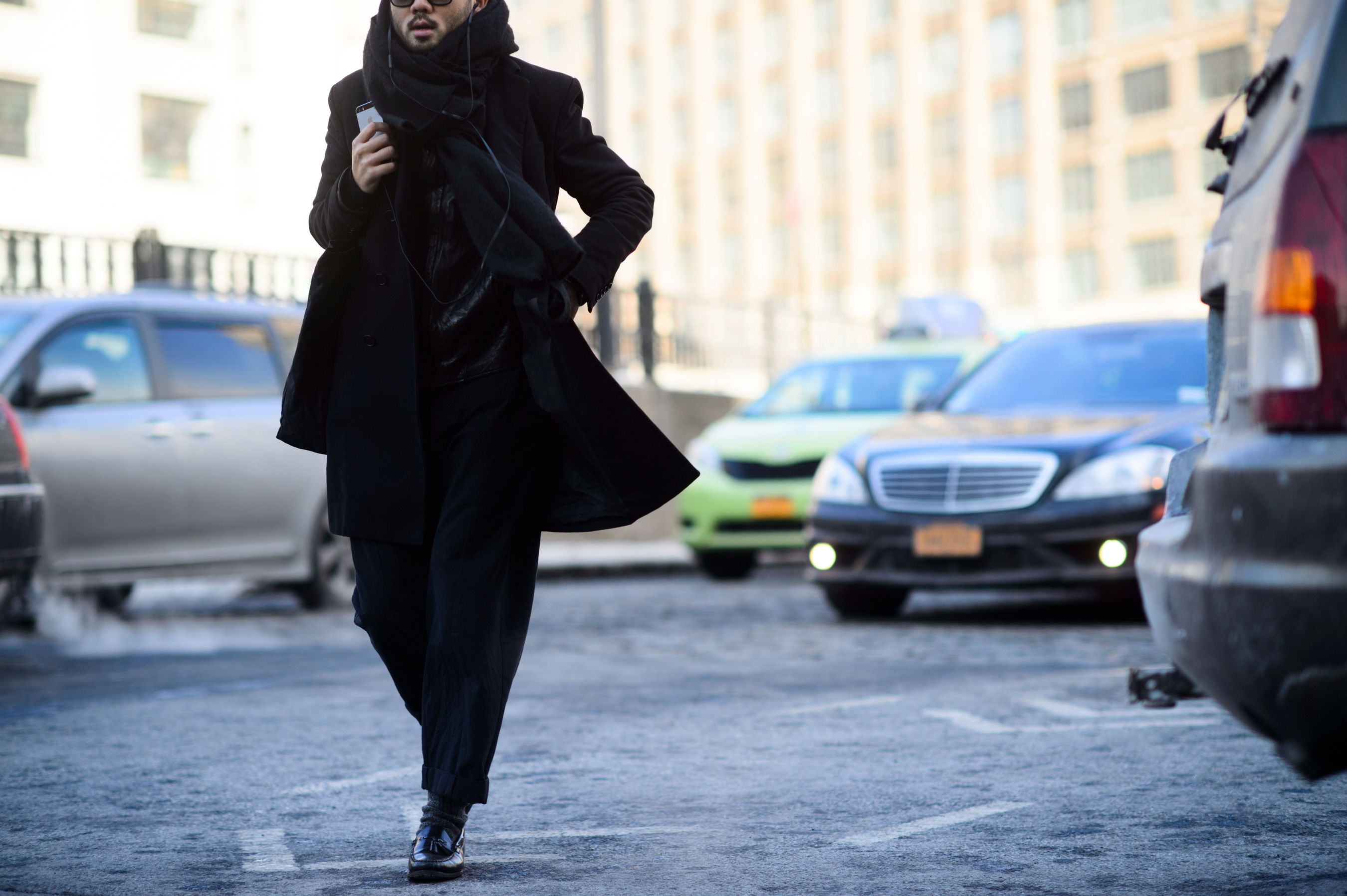 Man wearing black crosses the road