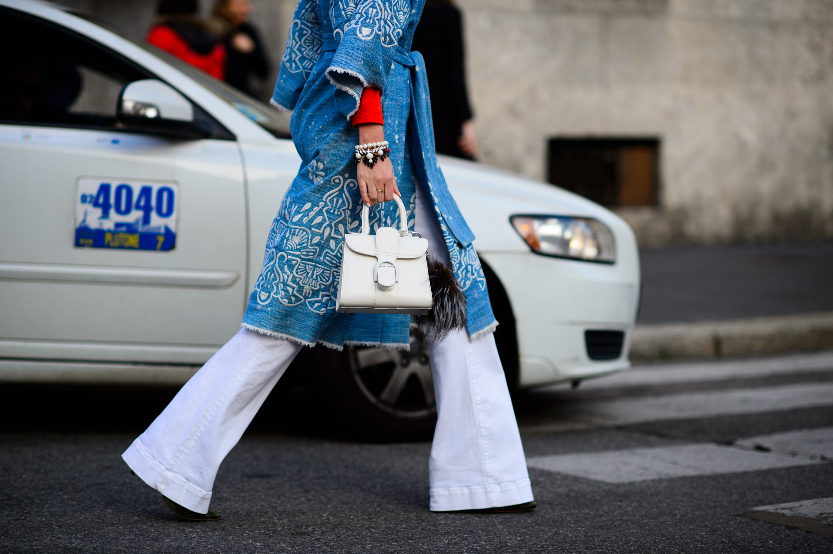 Blogger wearing blue coat and white pants