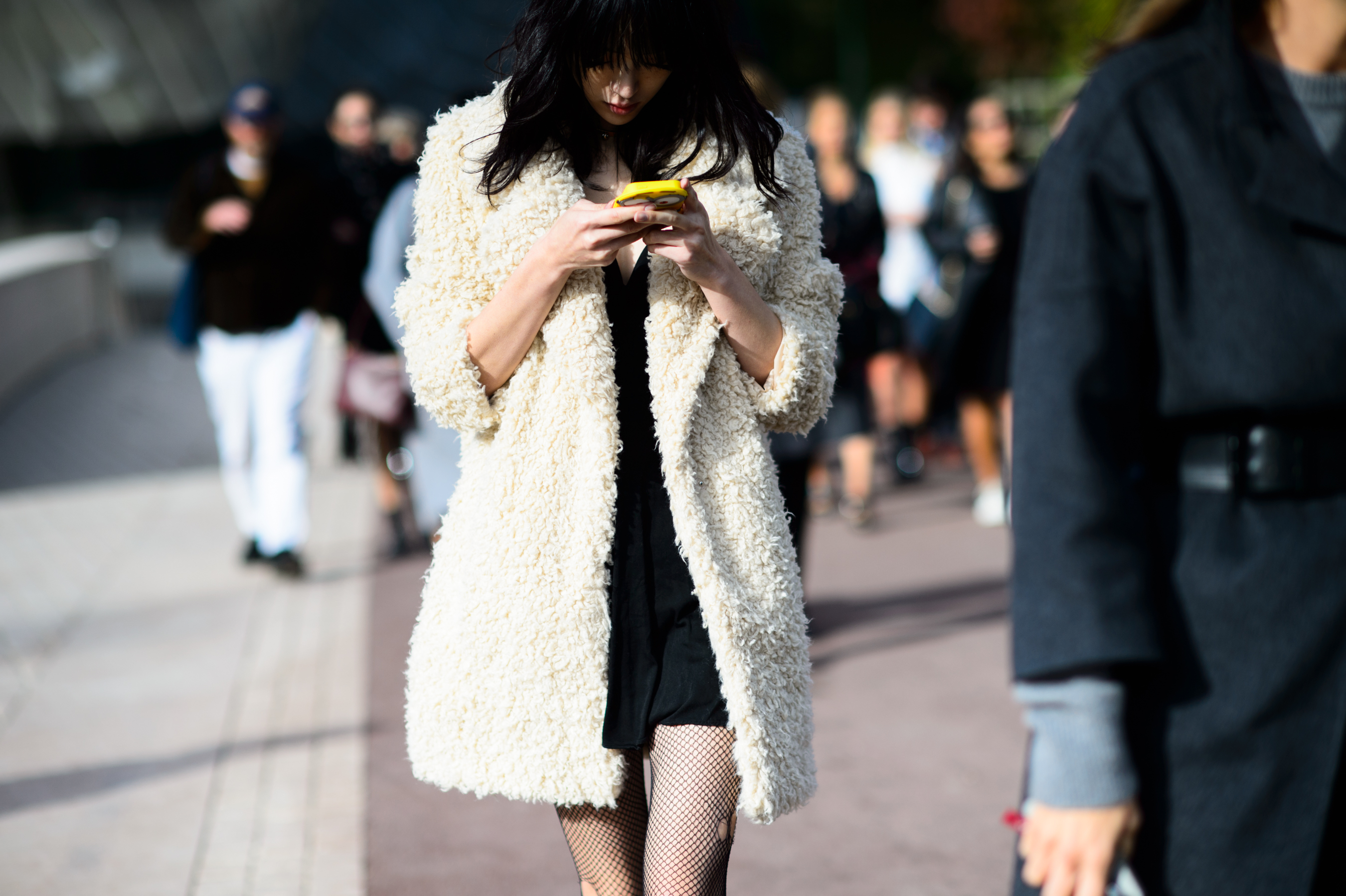 Model wearing white coat leaving the show