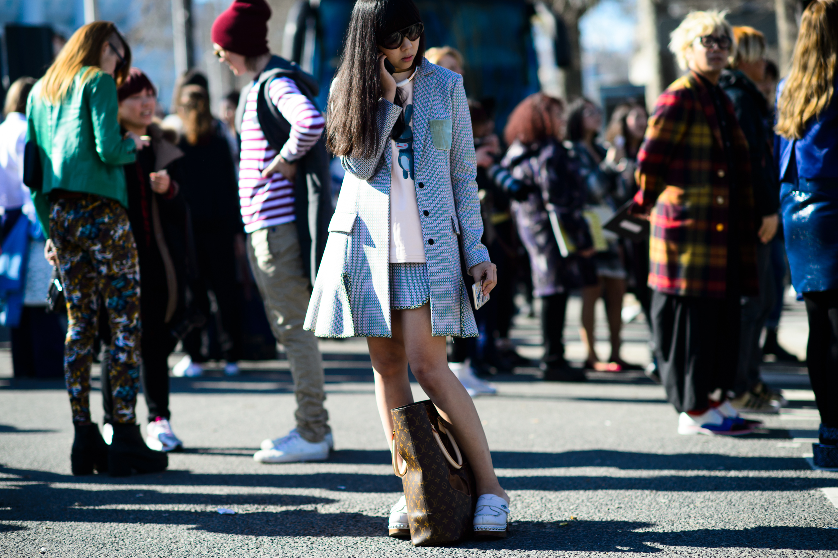 British blogger wearing suit with bag at her feet