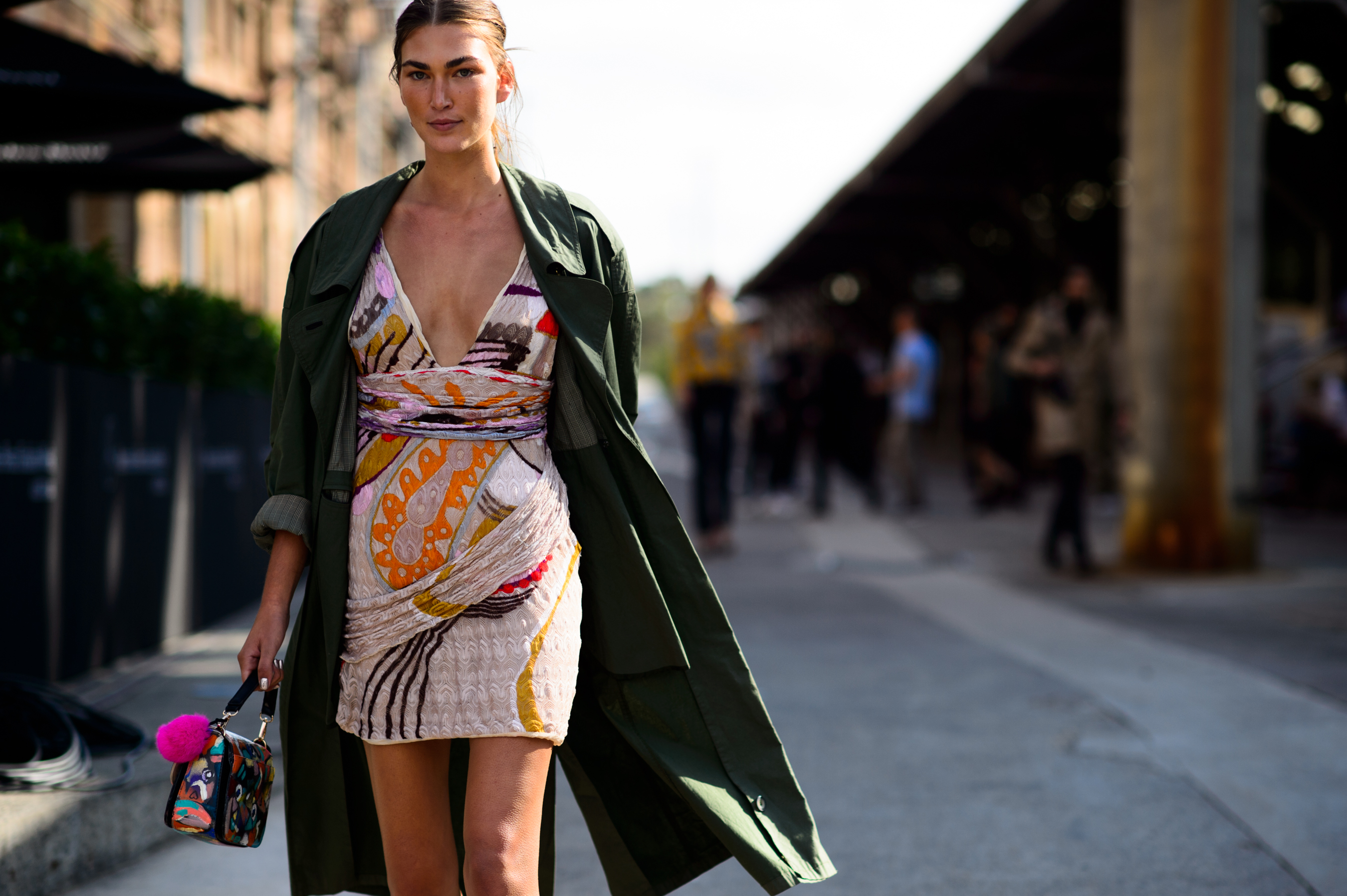 Model wearing dress and khaki coat