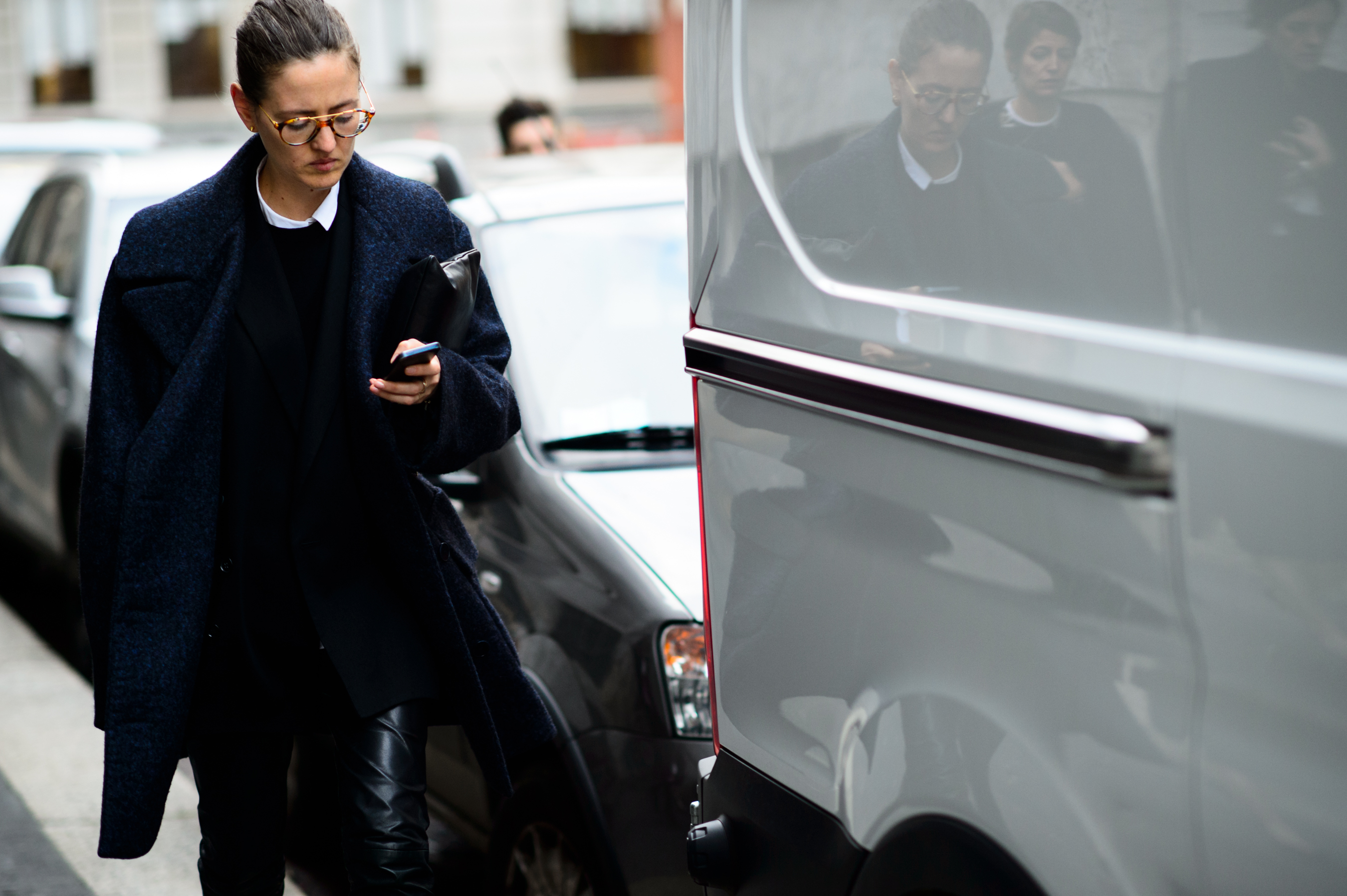 Stylist wearing blue coat and glasses