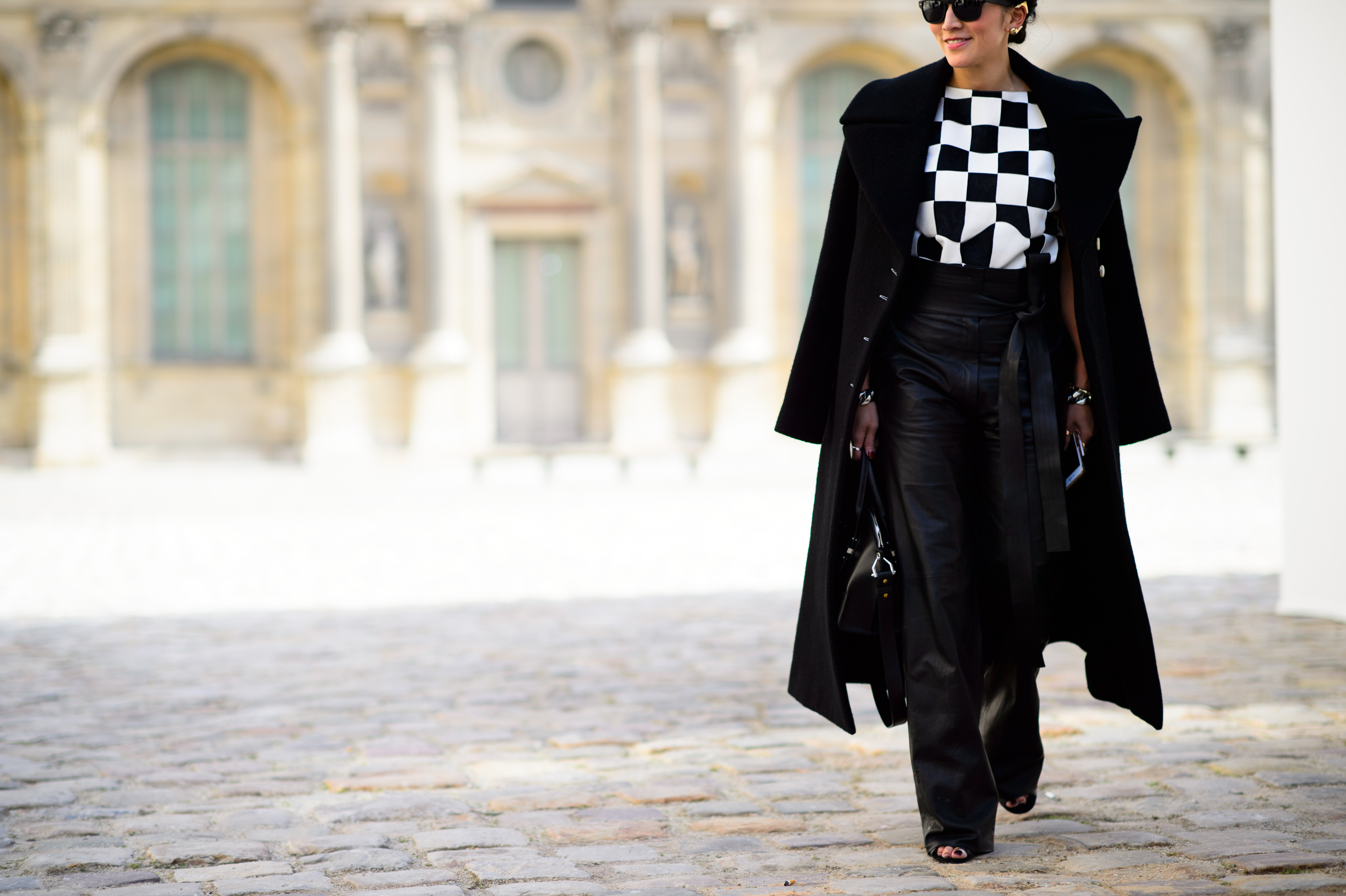 Asian woman wearing long black coat and graphic top