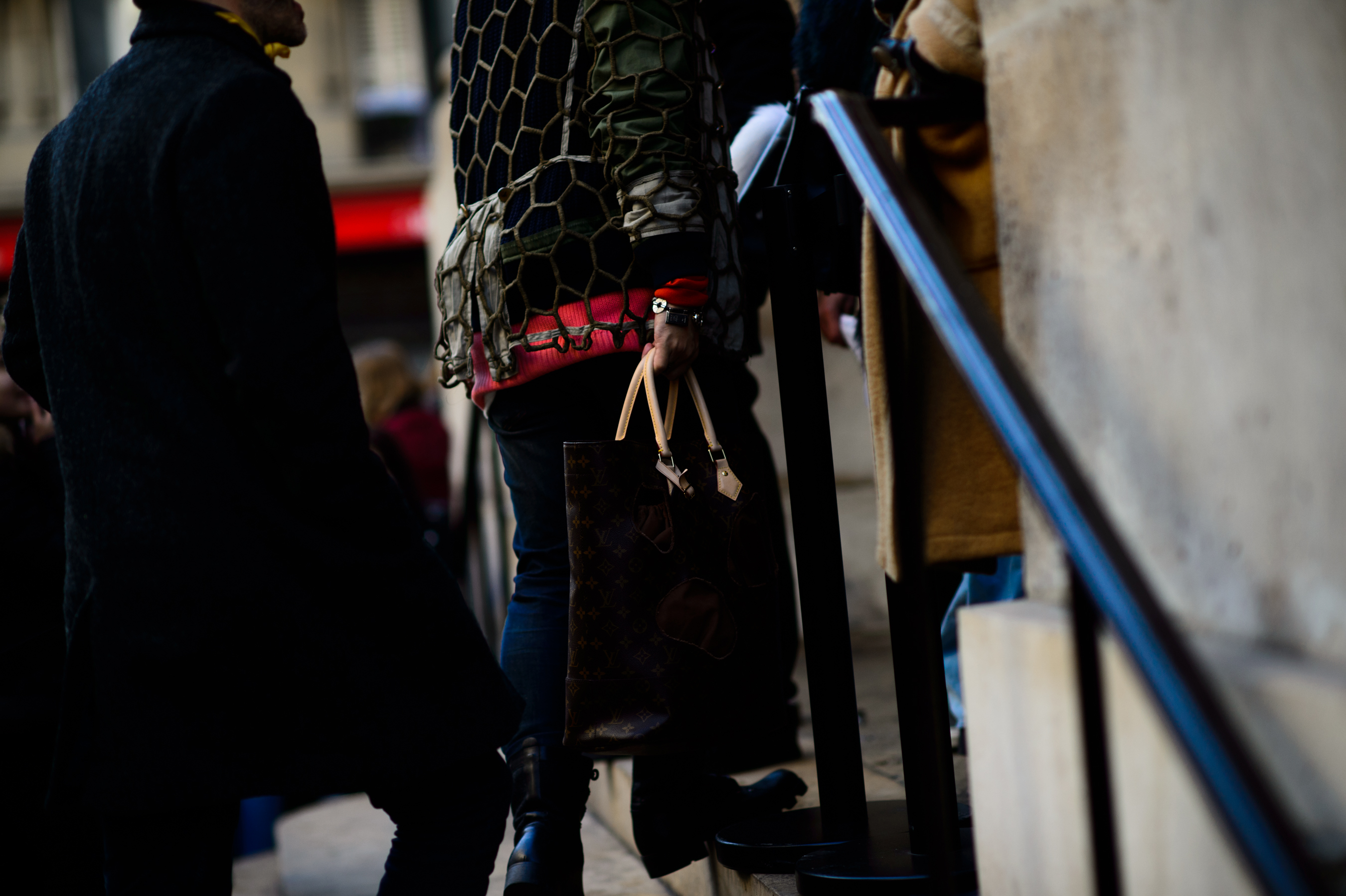 Woman holding Louis Vuitton x CDG collaboration bag