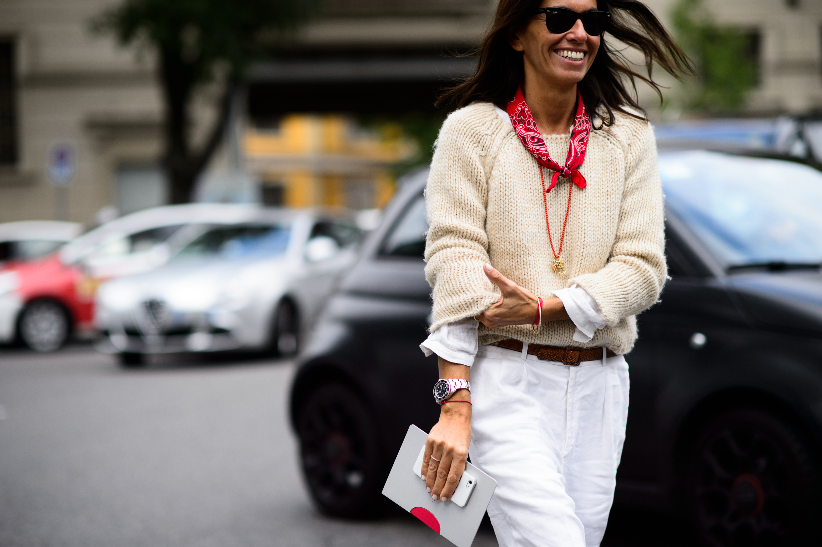 Woman wearing off white sweater with red scarf
