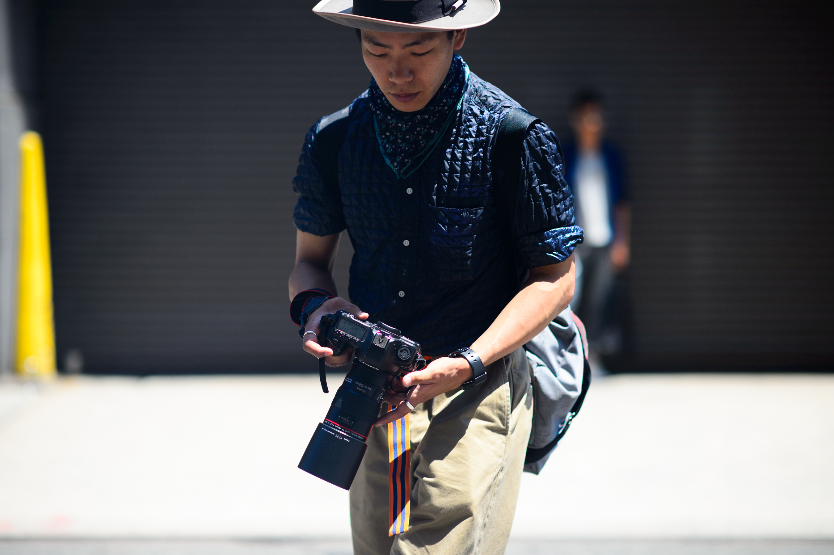 Street style photographer wearing vest and a hat