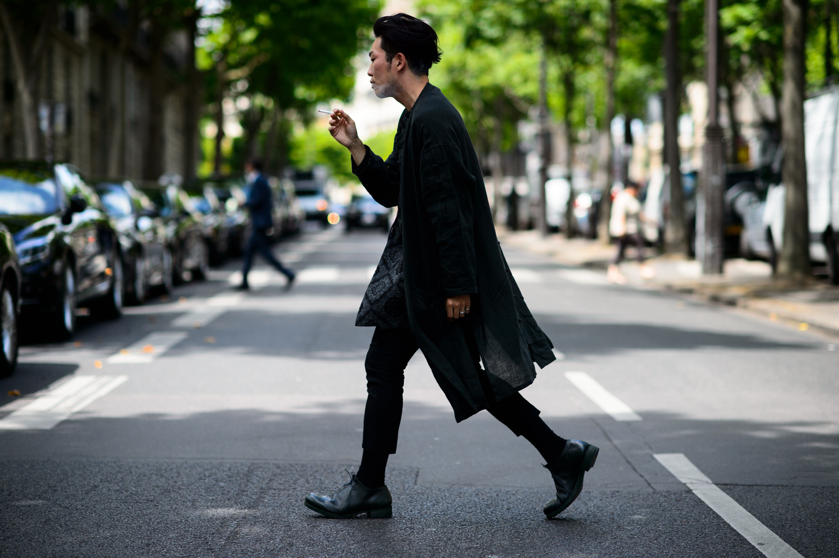 Man dressed in black crossing the road