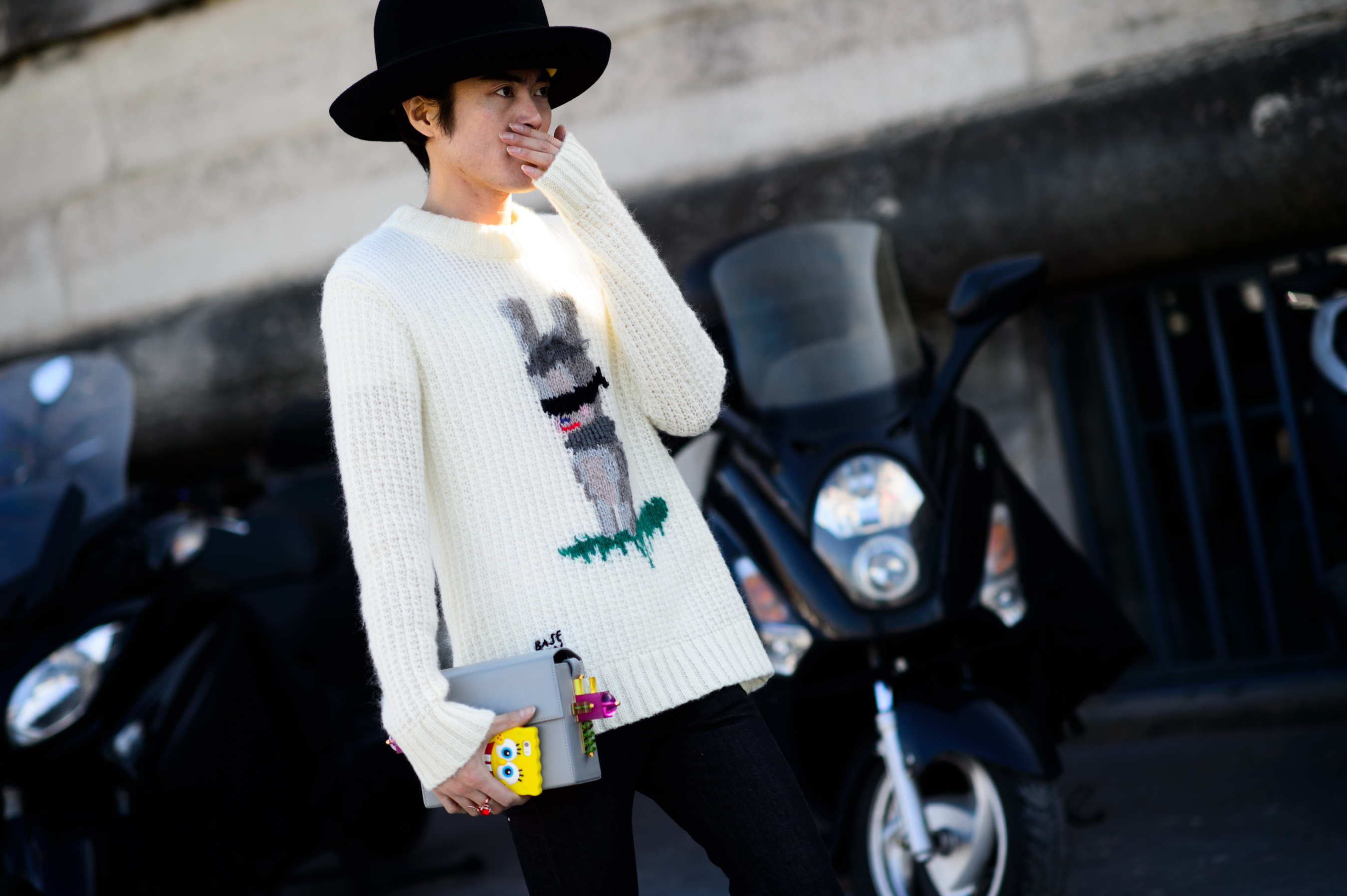 Asian man wearing sweater with cartoon character
