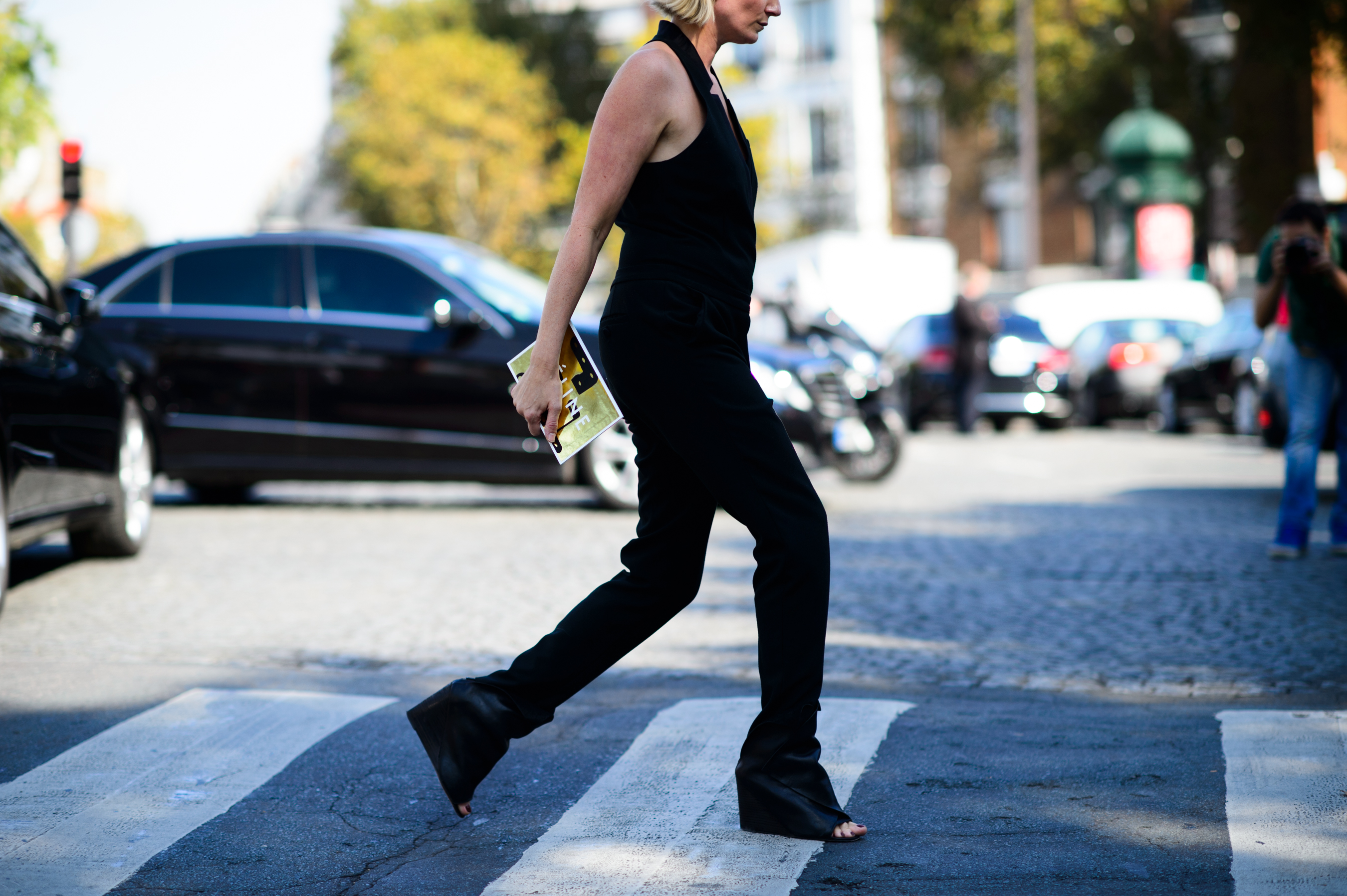 Woman in black jumpsuit crossing the road