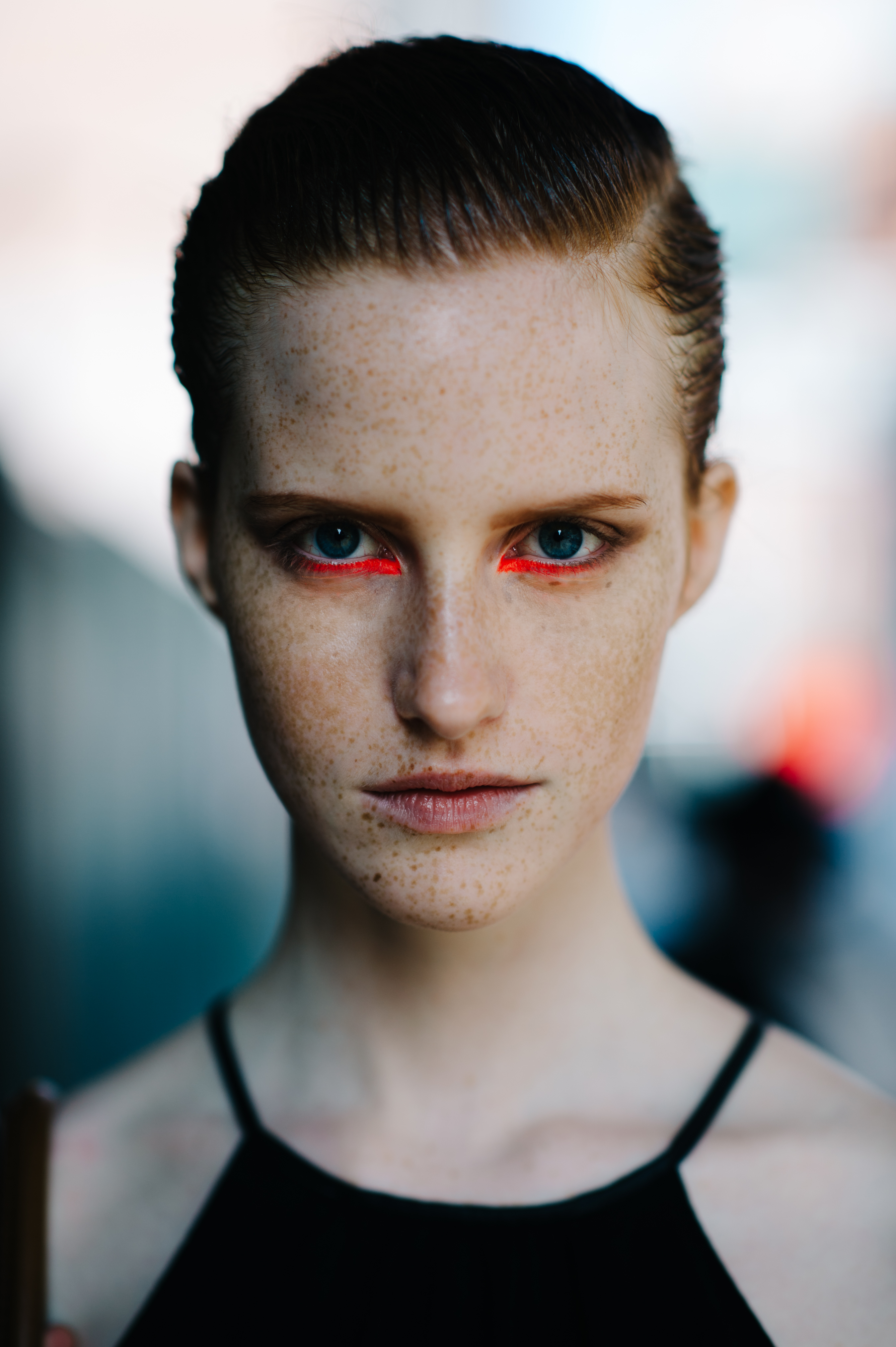 Model with freckles and pink neon make up