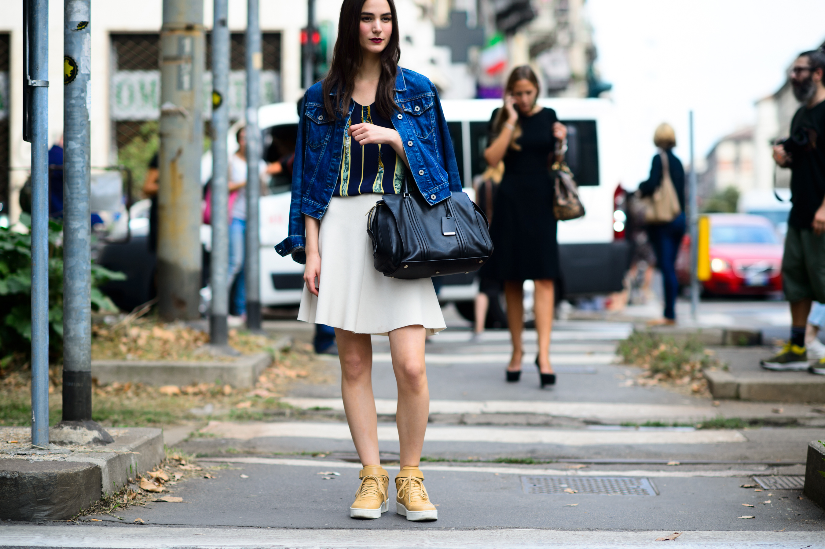Model wearing white skirt and denim jacket after the show