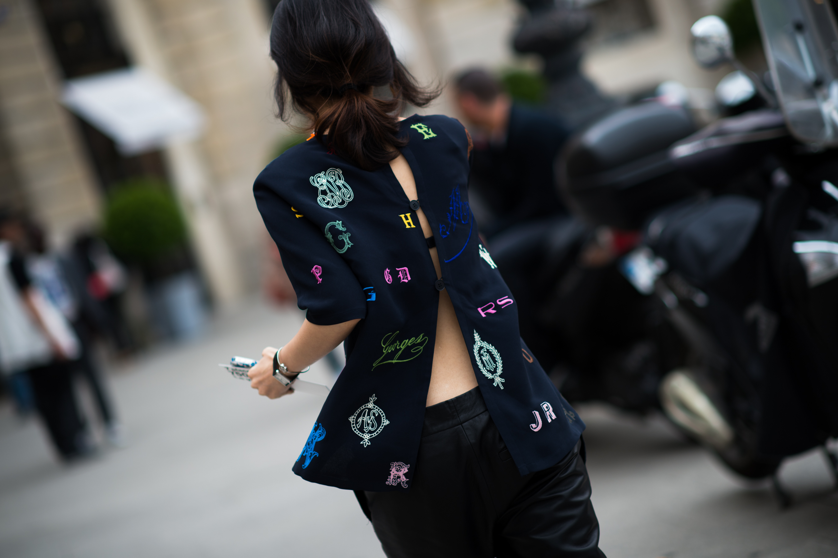 woman wearing open back jacket with patches