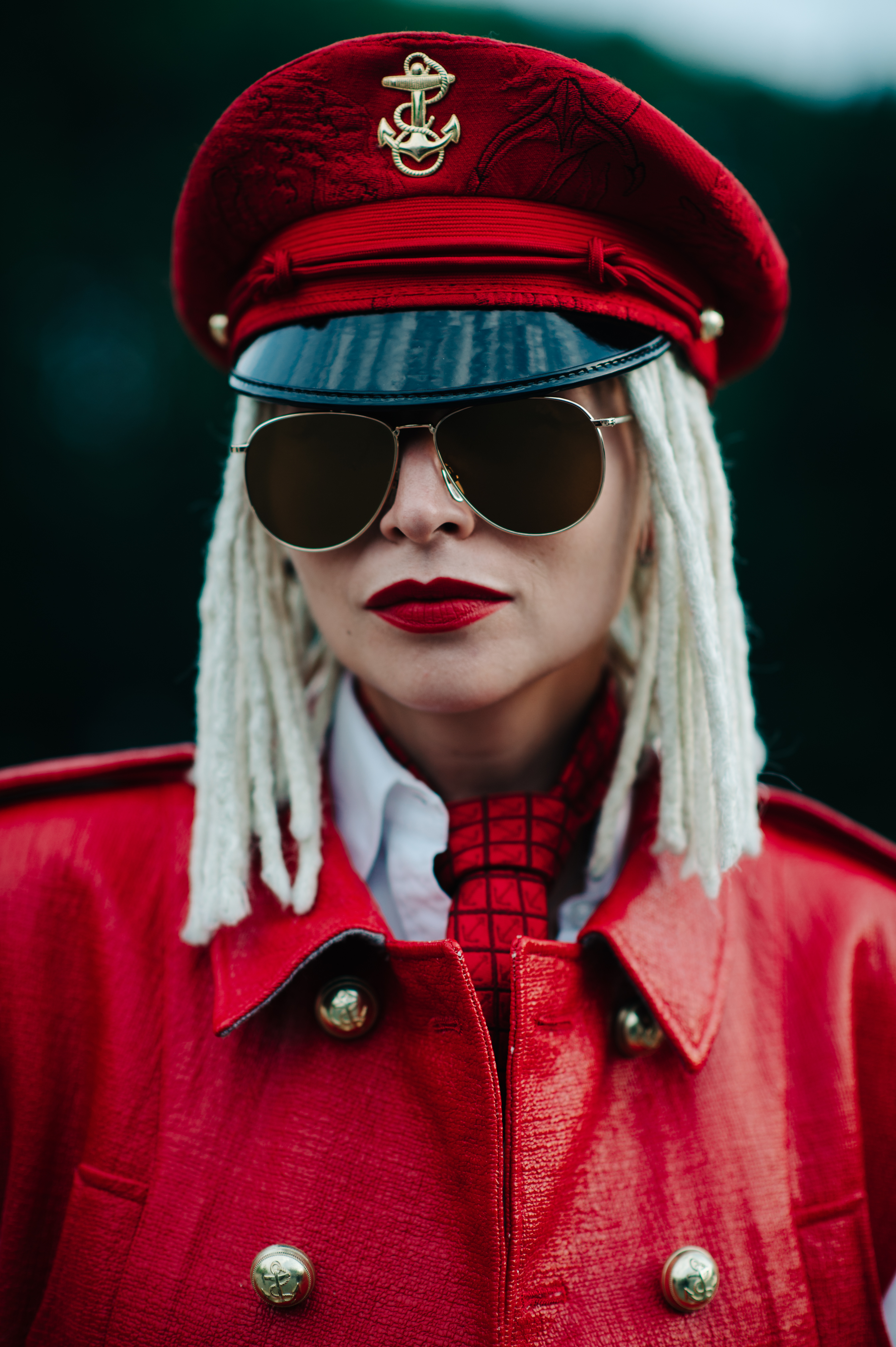 Portrait of a woman with blonde dreadlocks wearing red