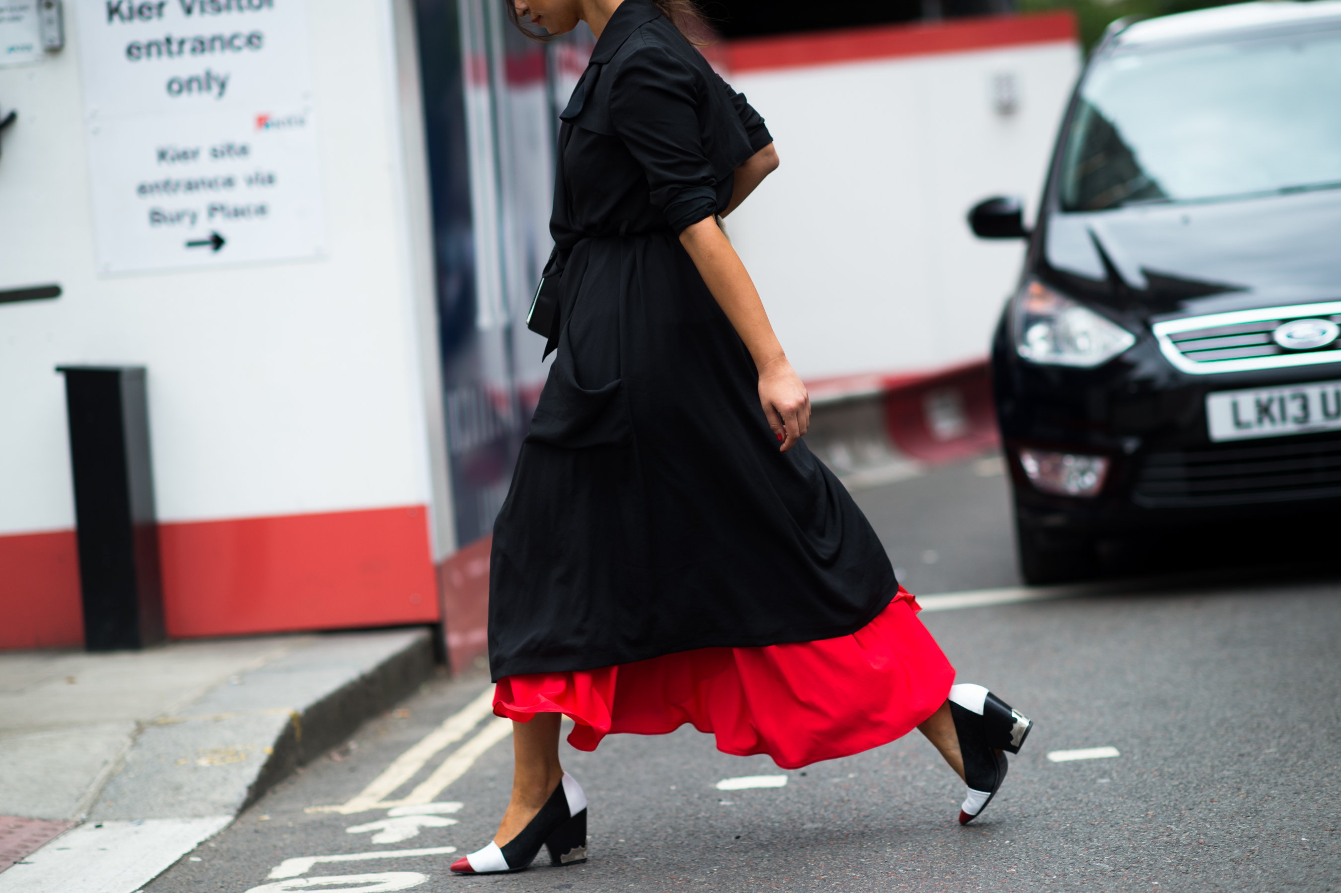 Woman wearing black coat and red dress