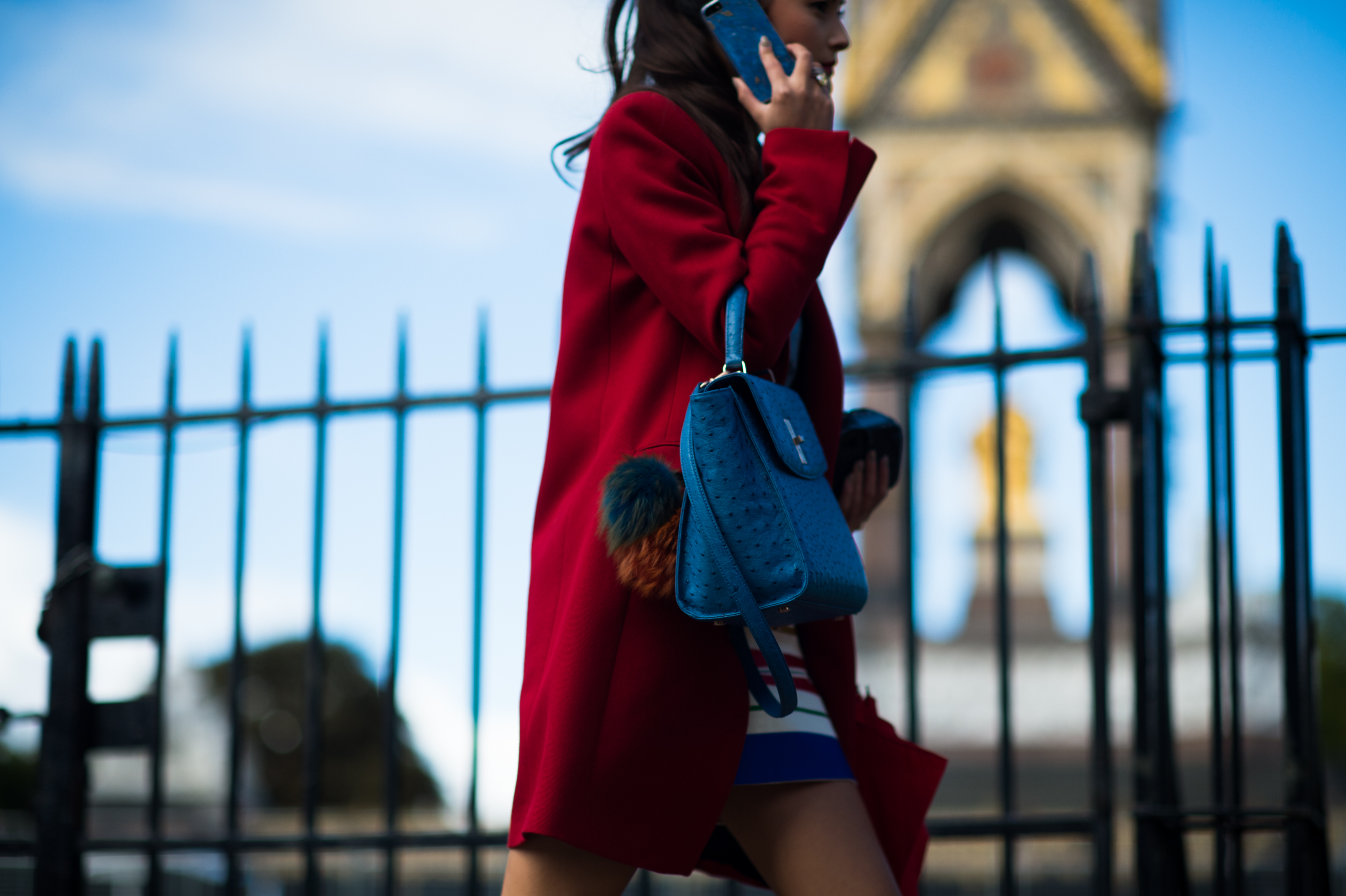 Girl wearing red coat with blue handbag