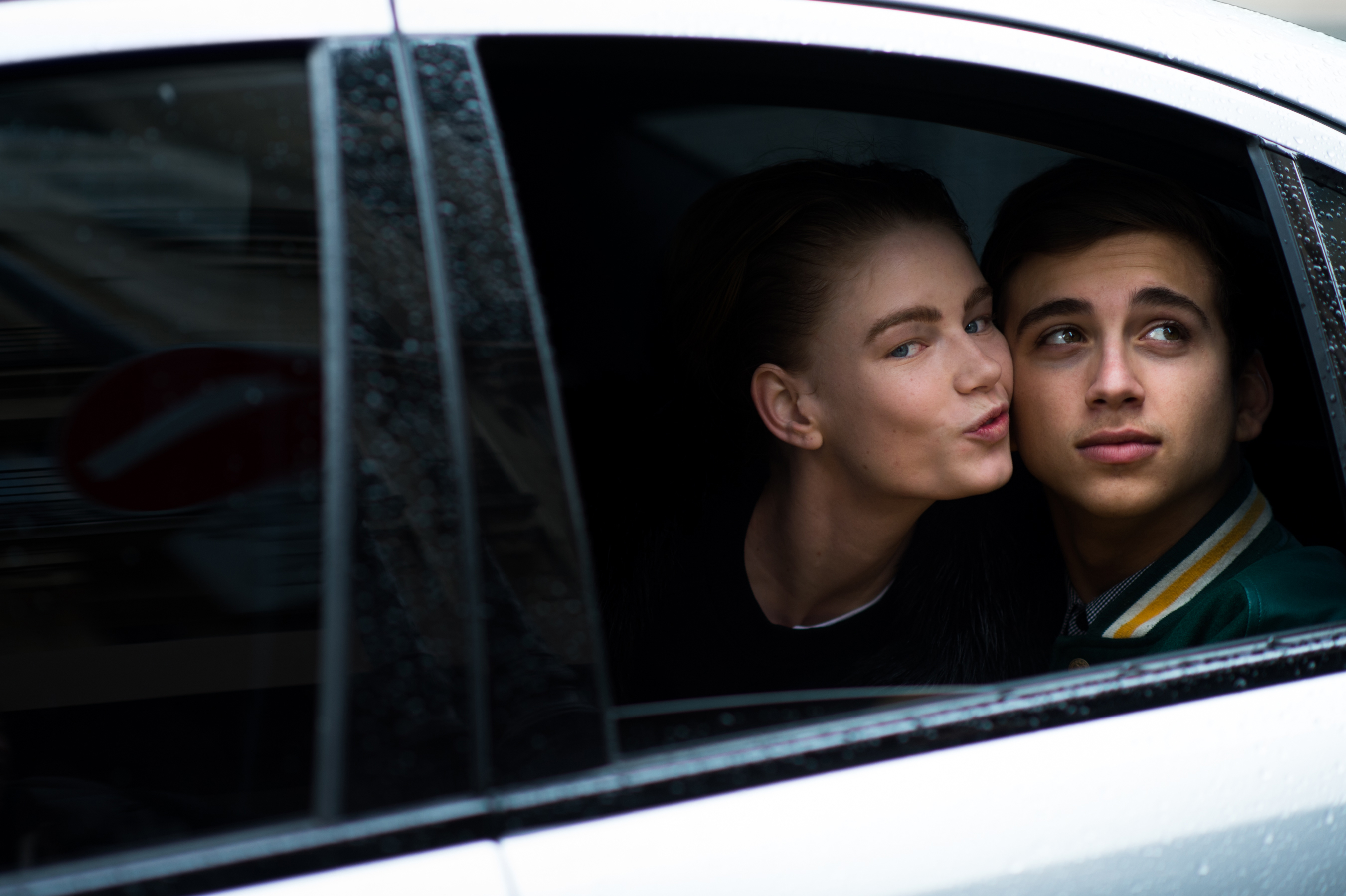 Model in a car kissing a guy