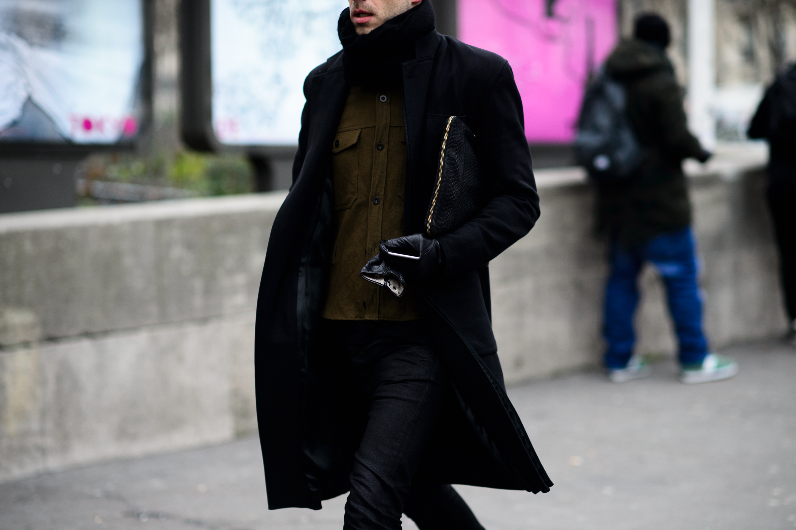 Man wearing coat and clutch bag