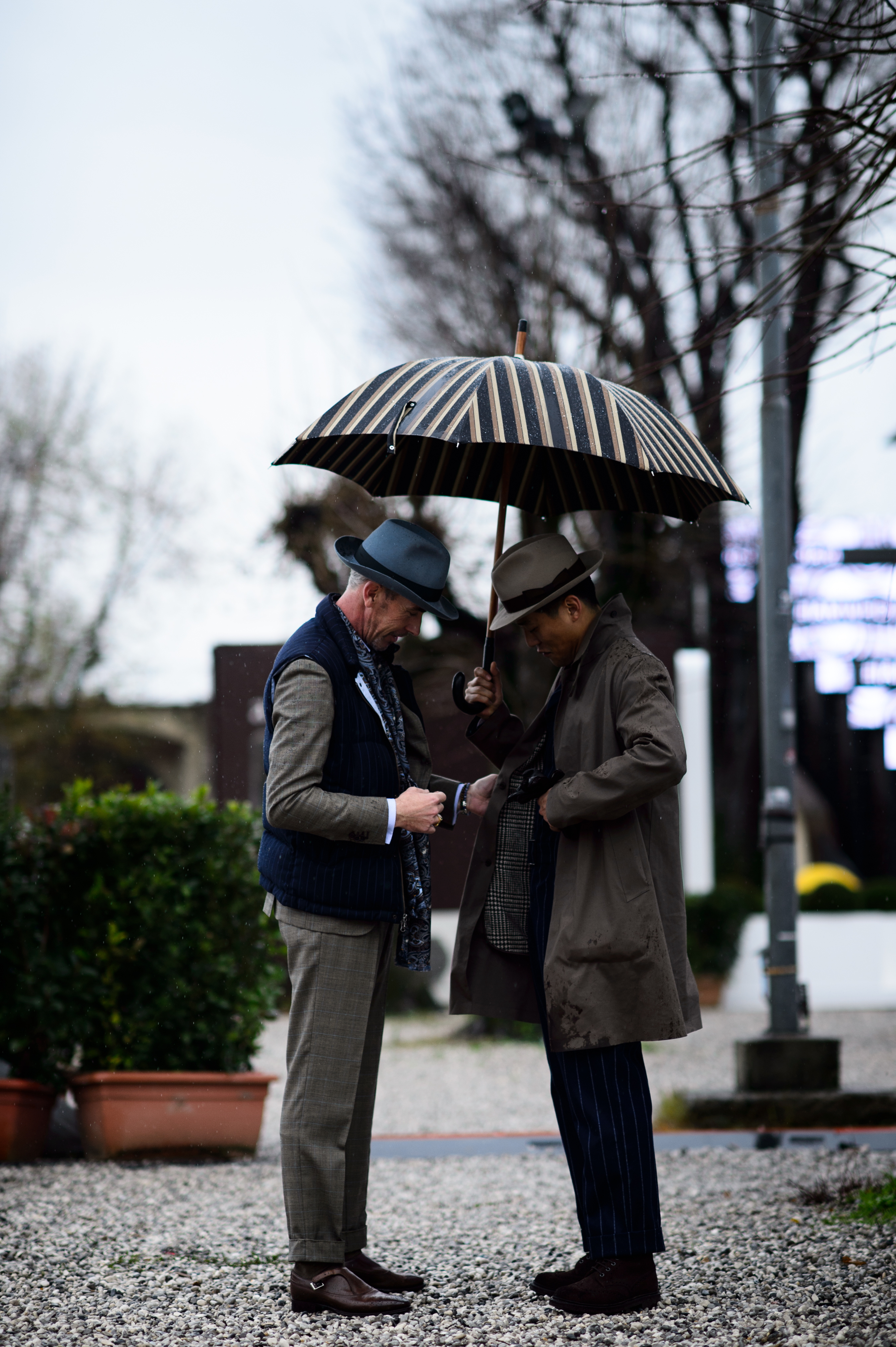 Two men wearing suits umbrella