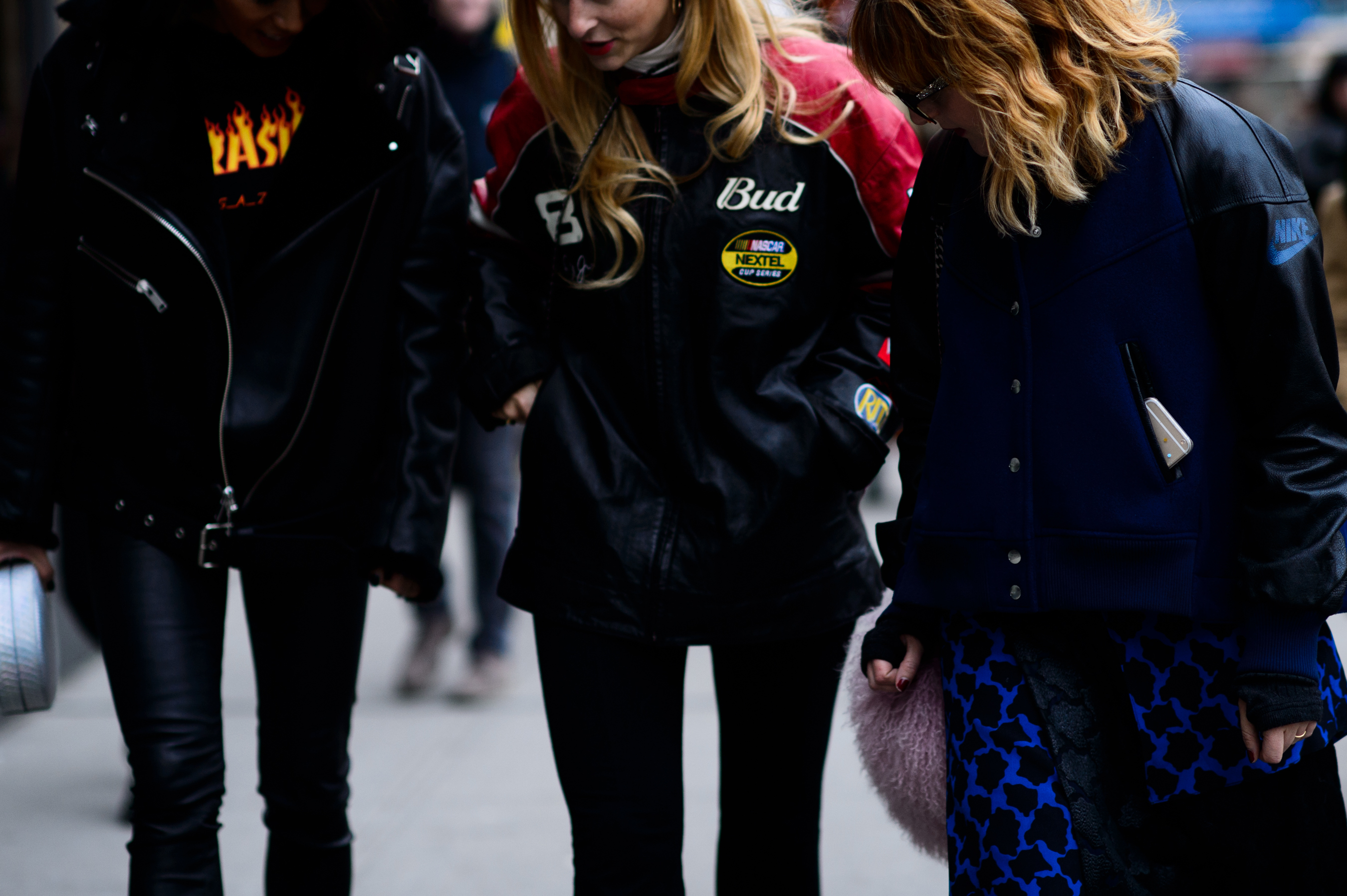 Three women wearing bomber jackets