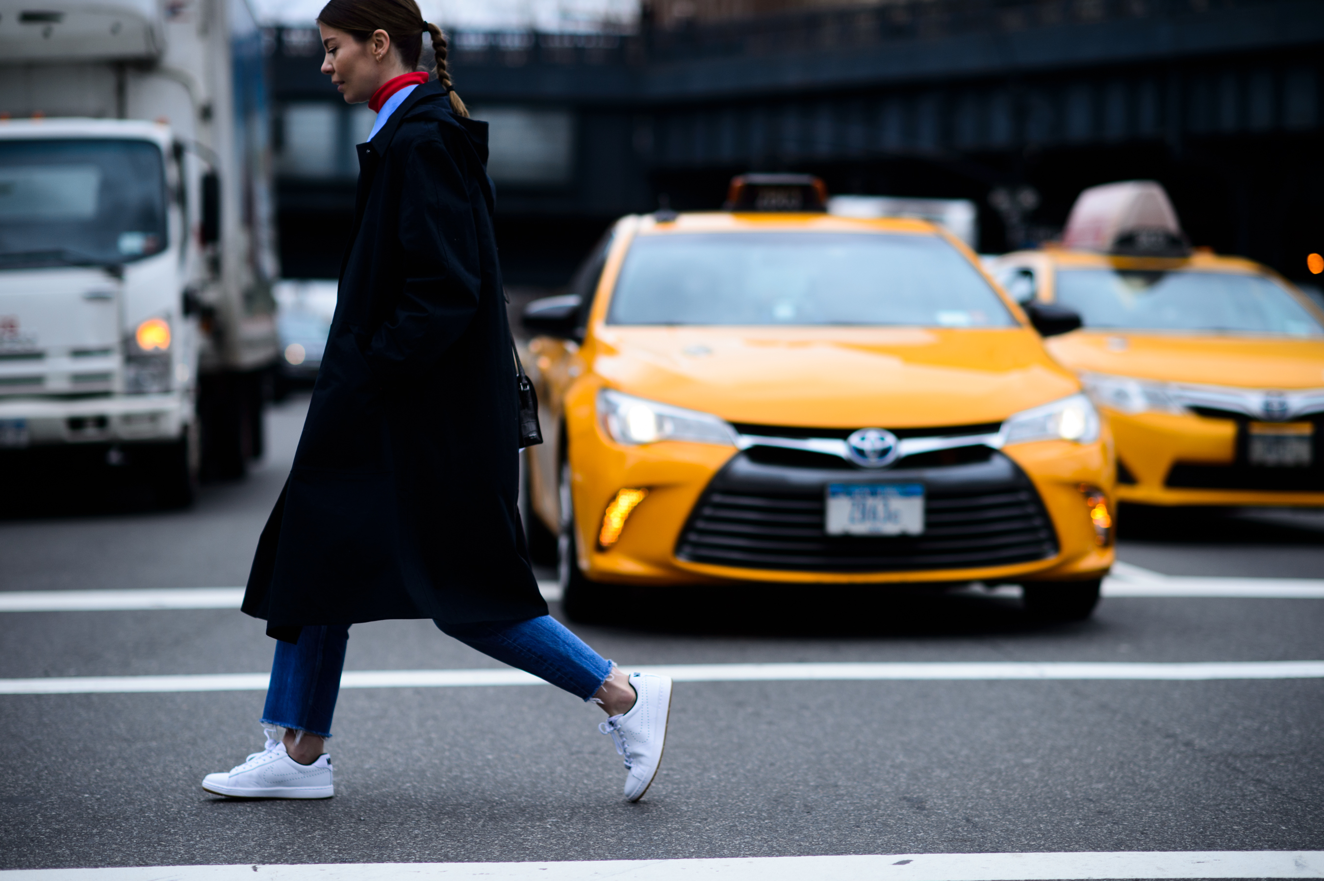 Woman wearing coat crosses the road