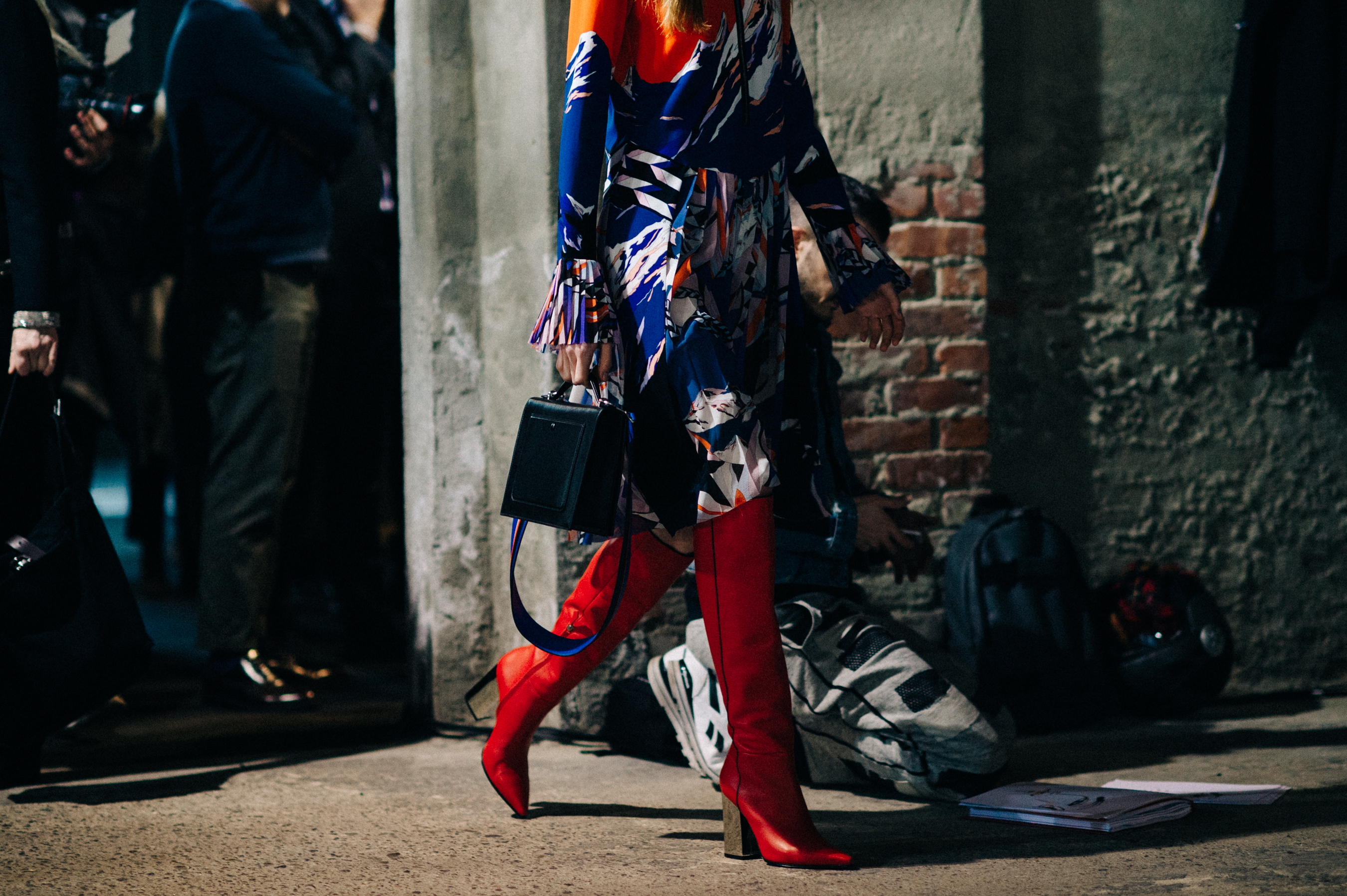 Model wearing printed dress red boots
