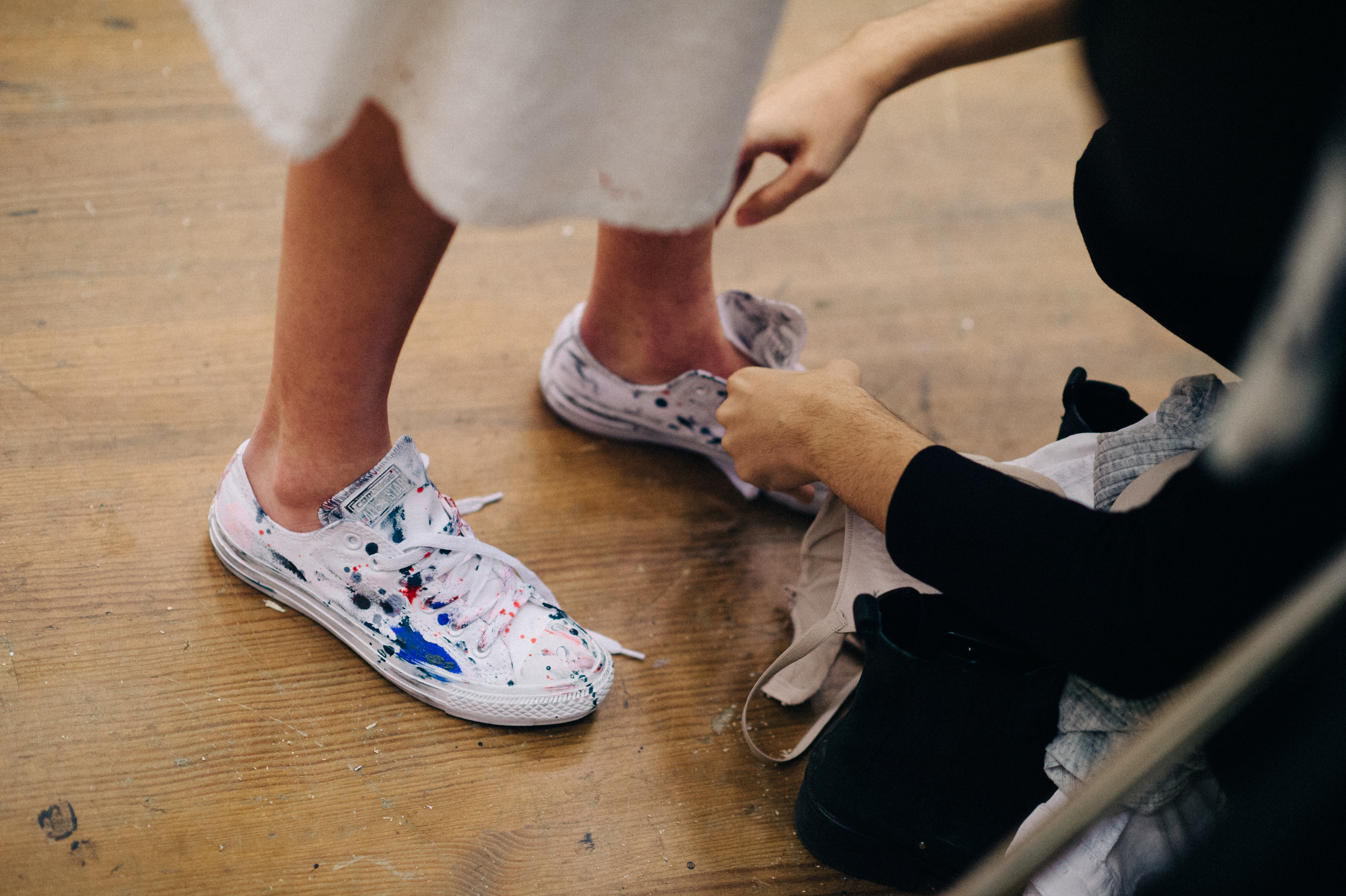 Dresser putting colourful converse on