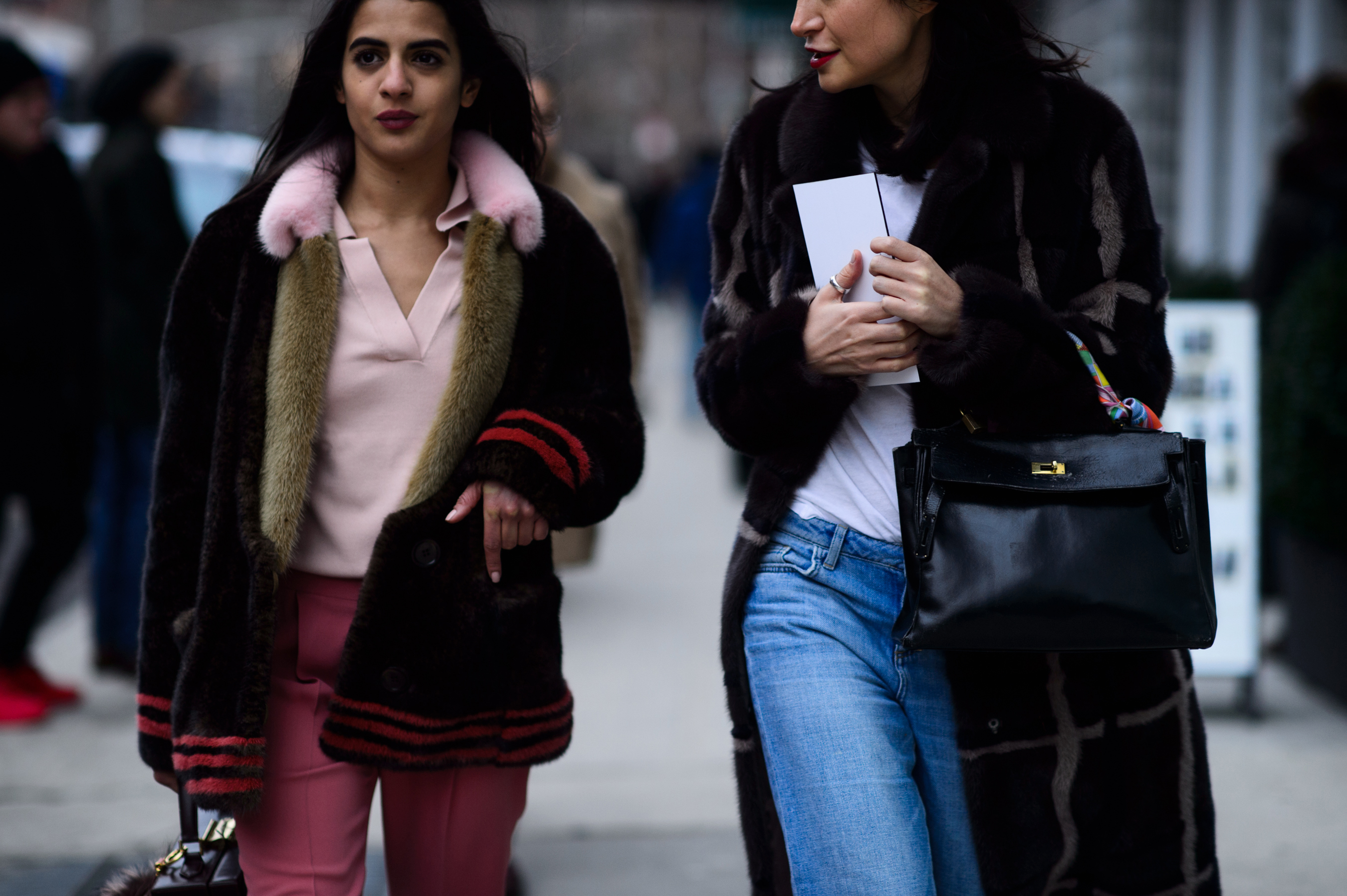 Two women wearing fur coats