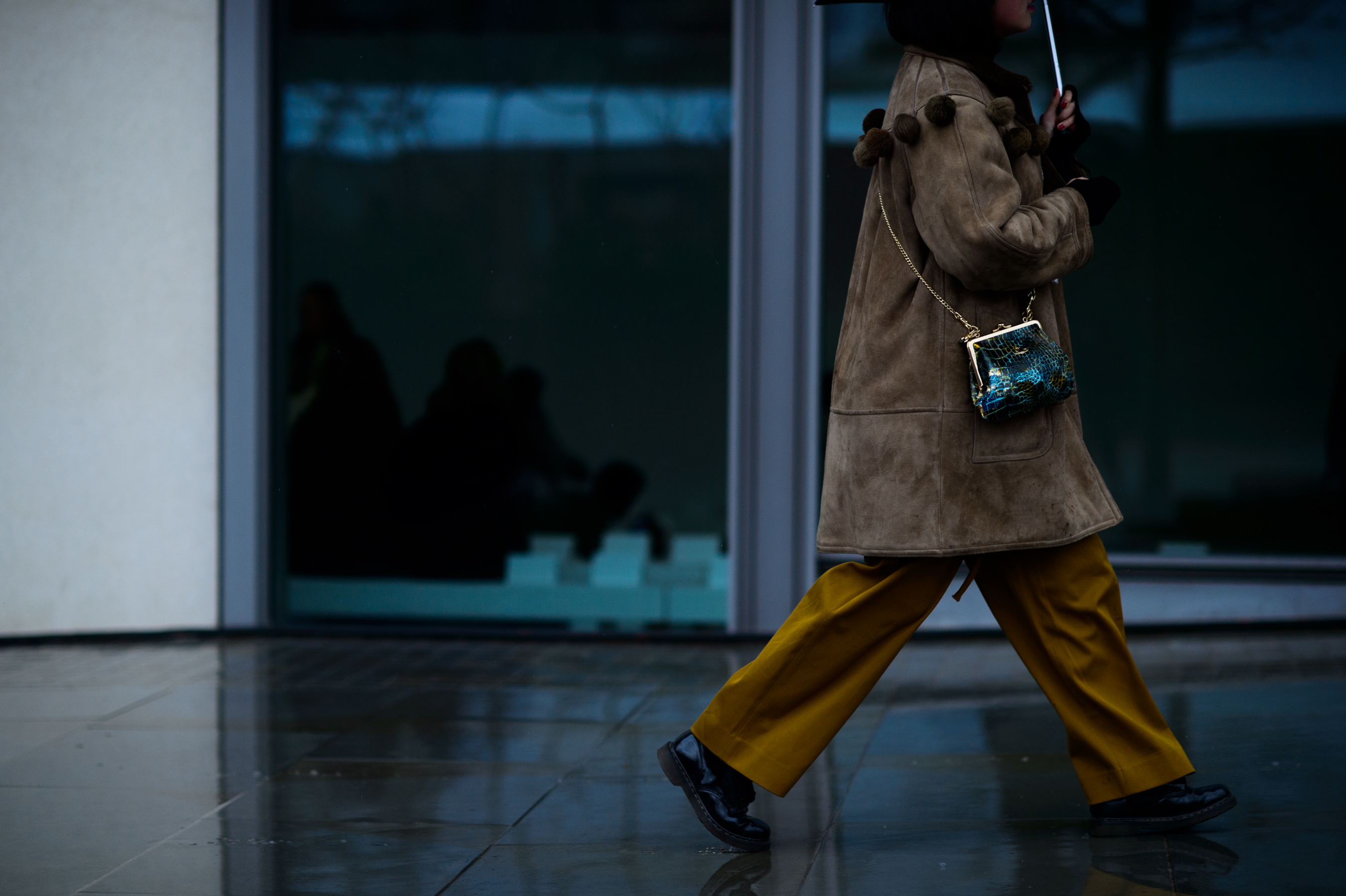 Woman wearing coat with fur pom-poms