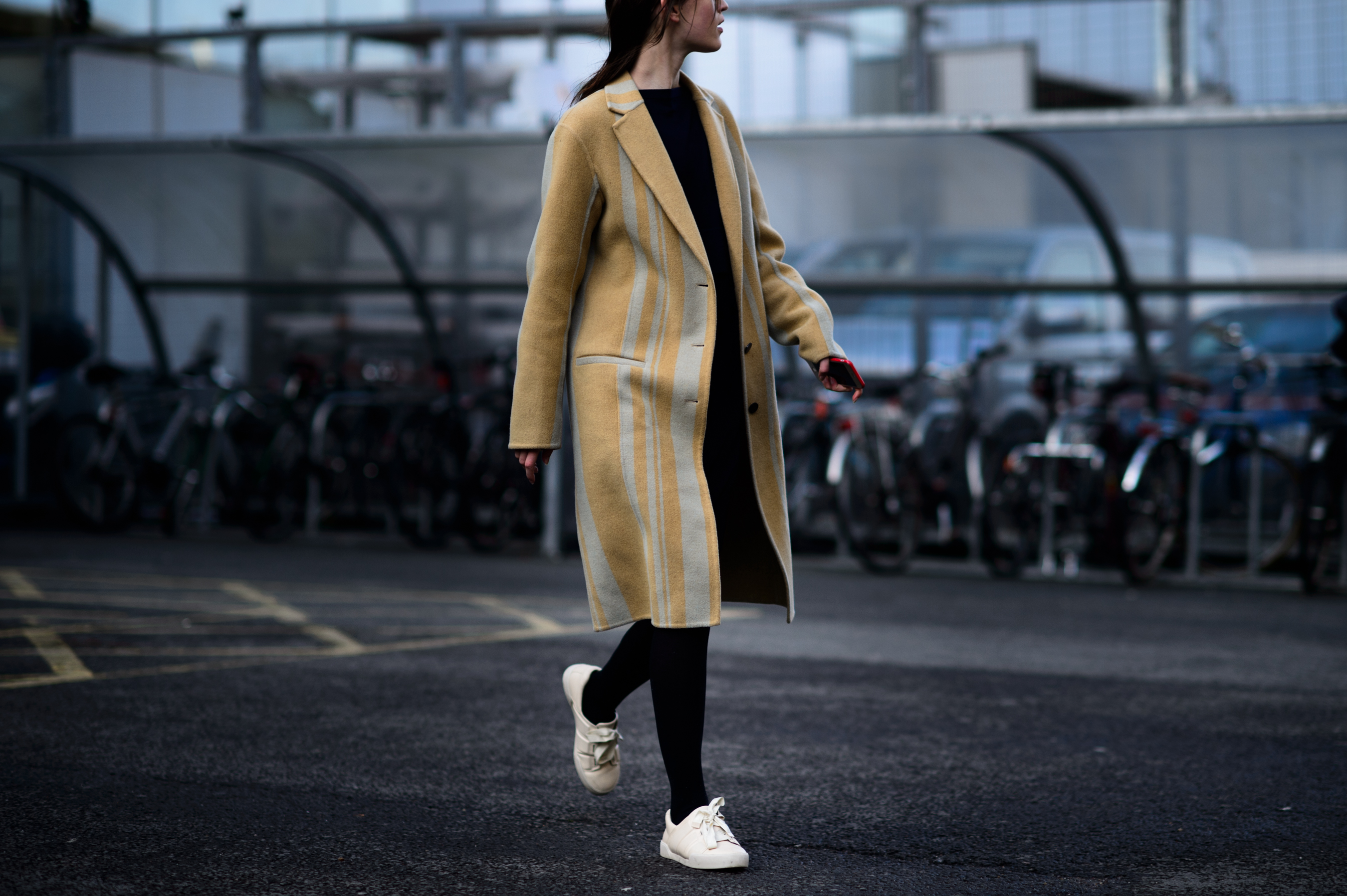 Model wearing coat and sneakers