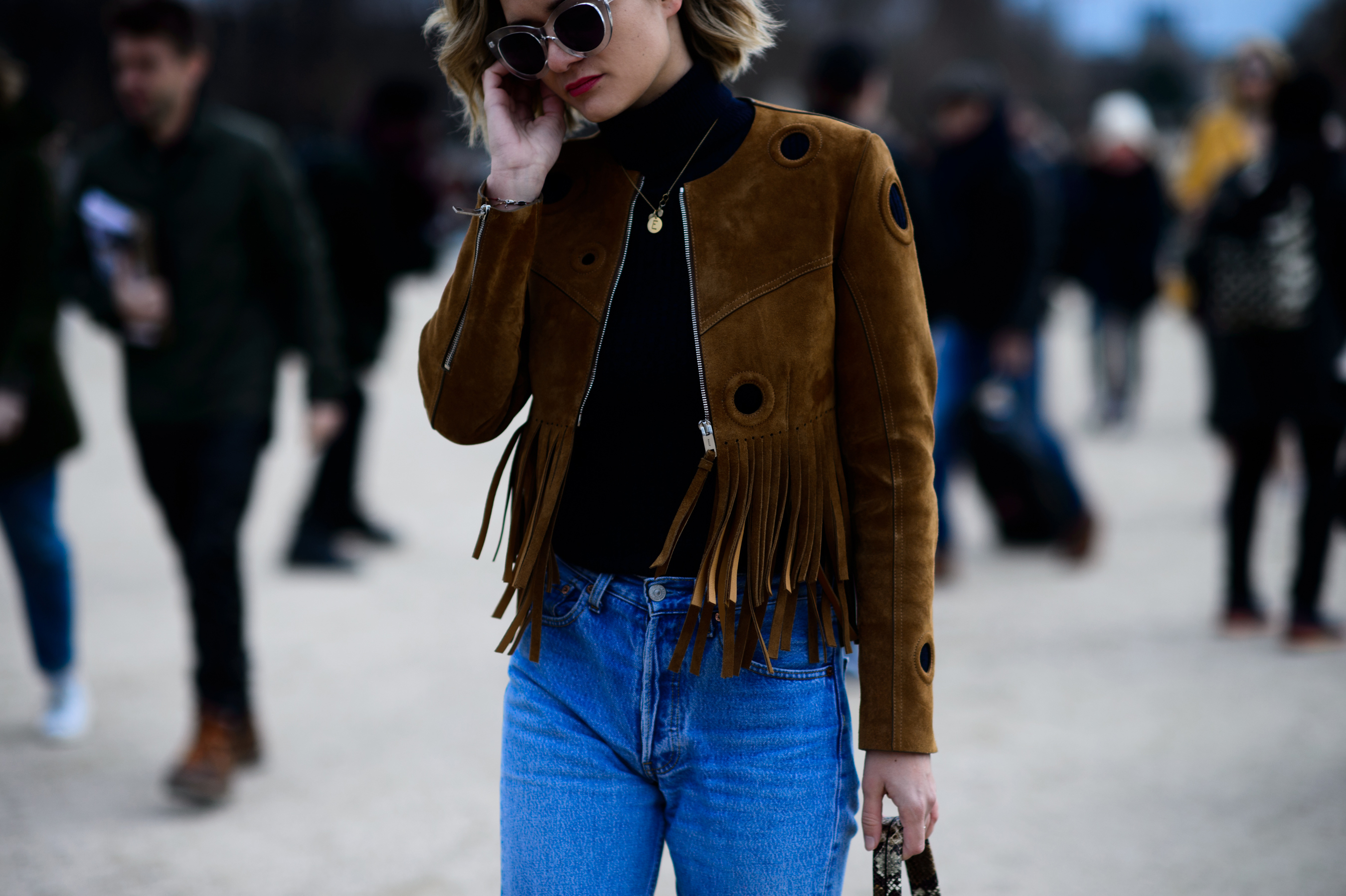 Woman wearing tasseled brown suede jacket