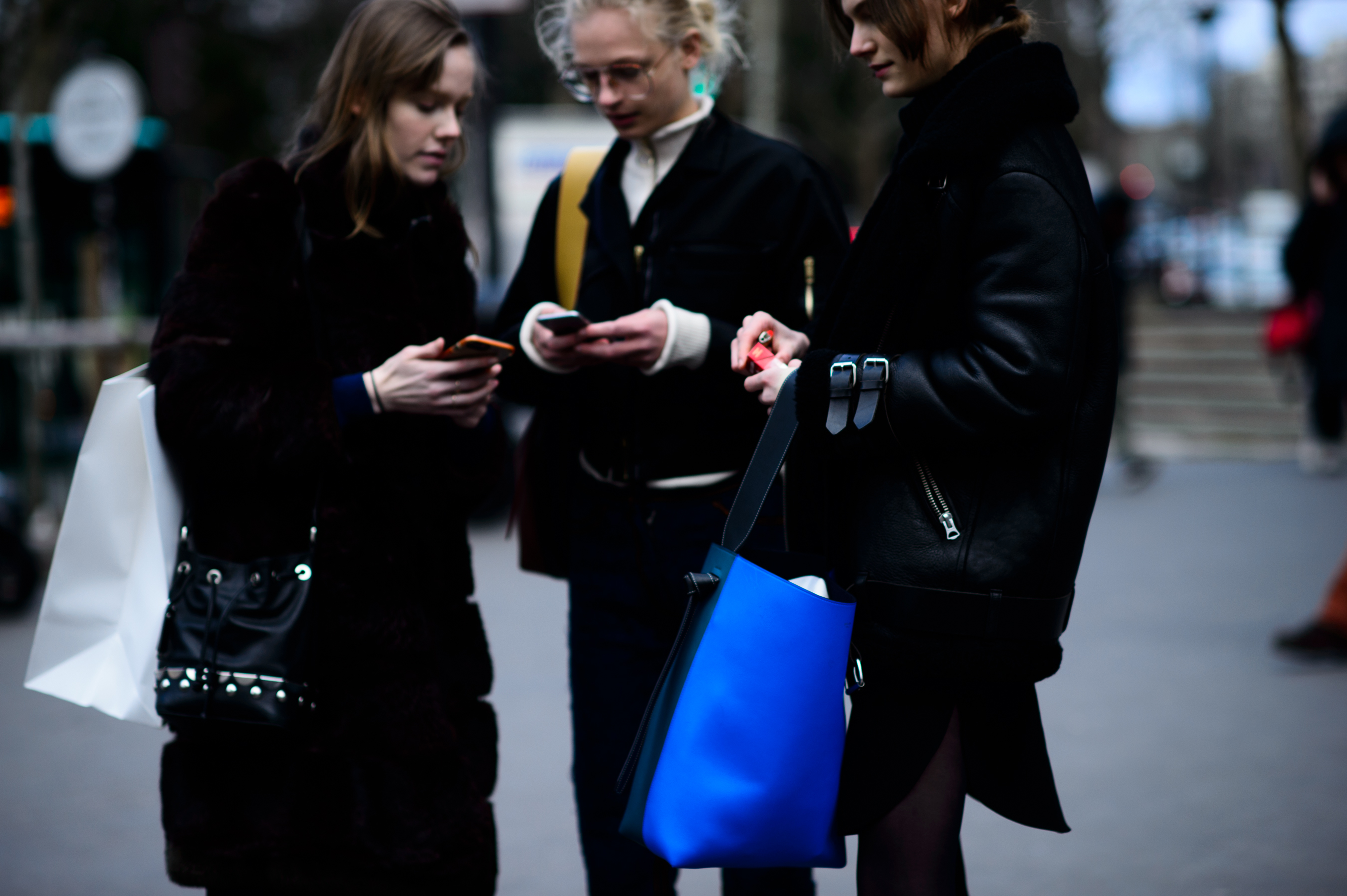 Three models in dark clothing after show