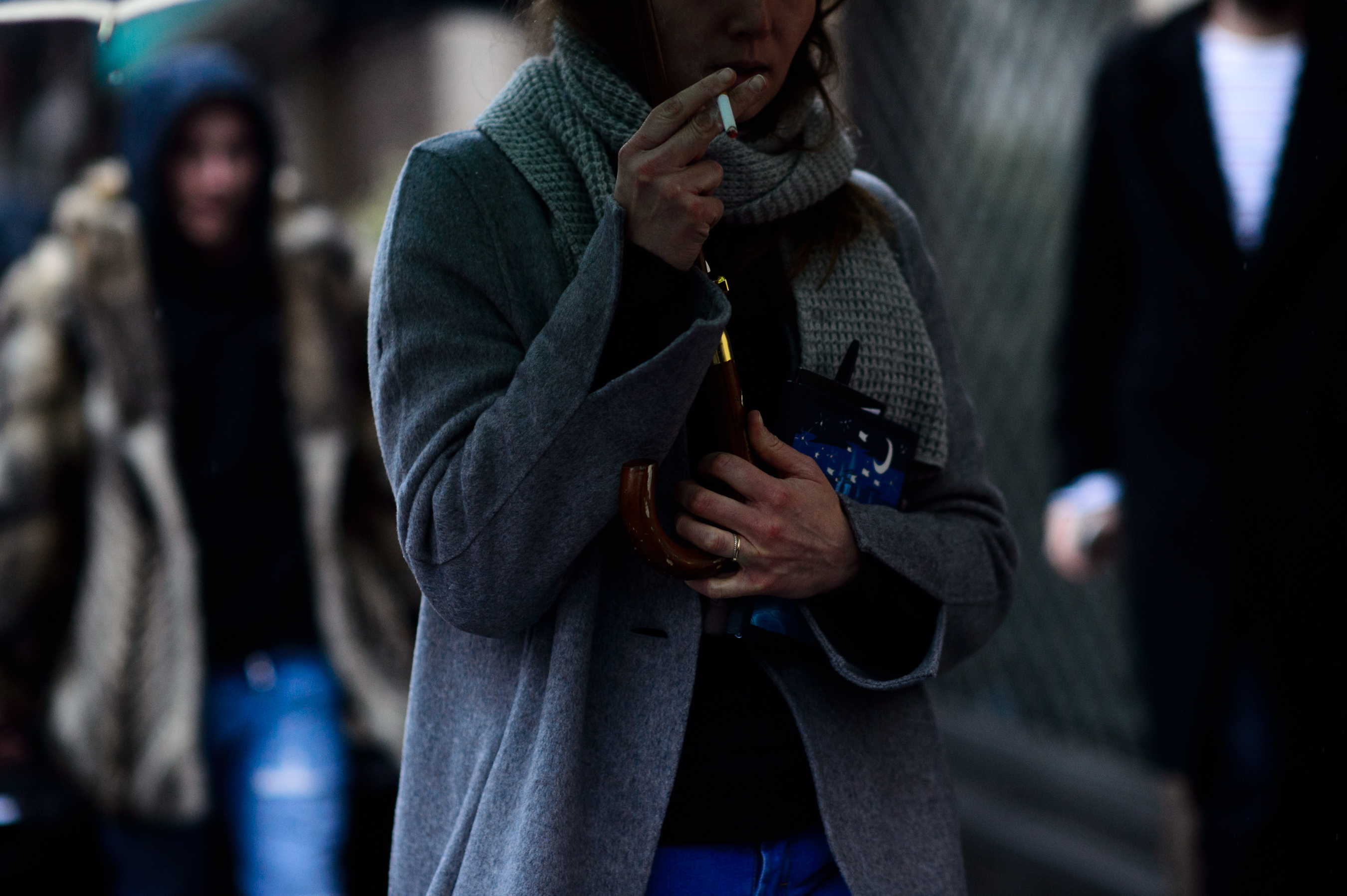 Woman in grey coat smoking