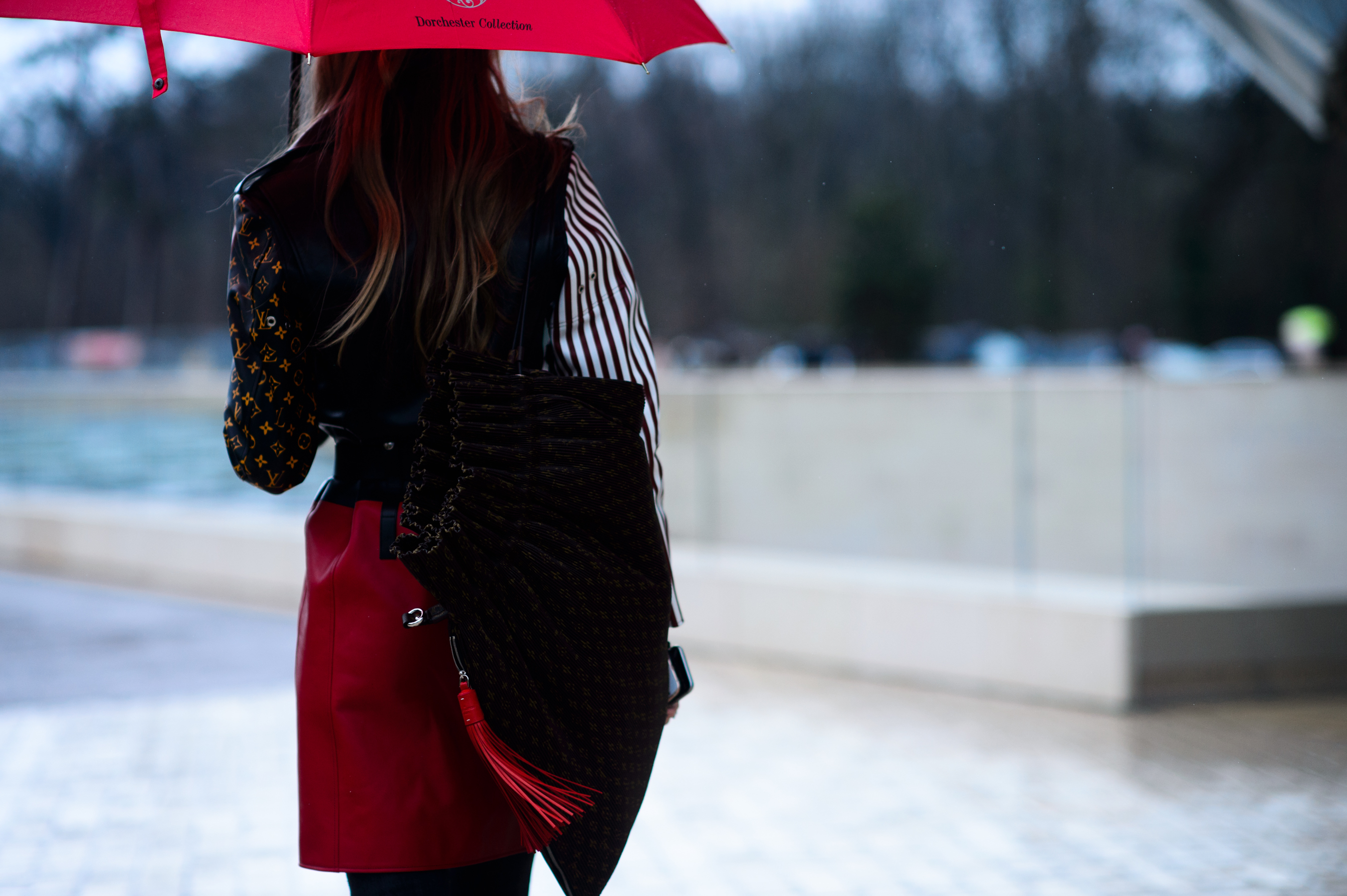 Back of woman with red umbrella, skirt and tassle