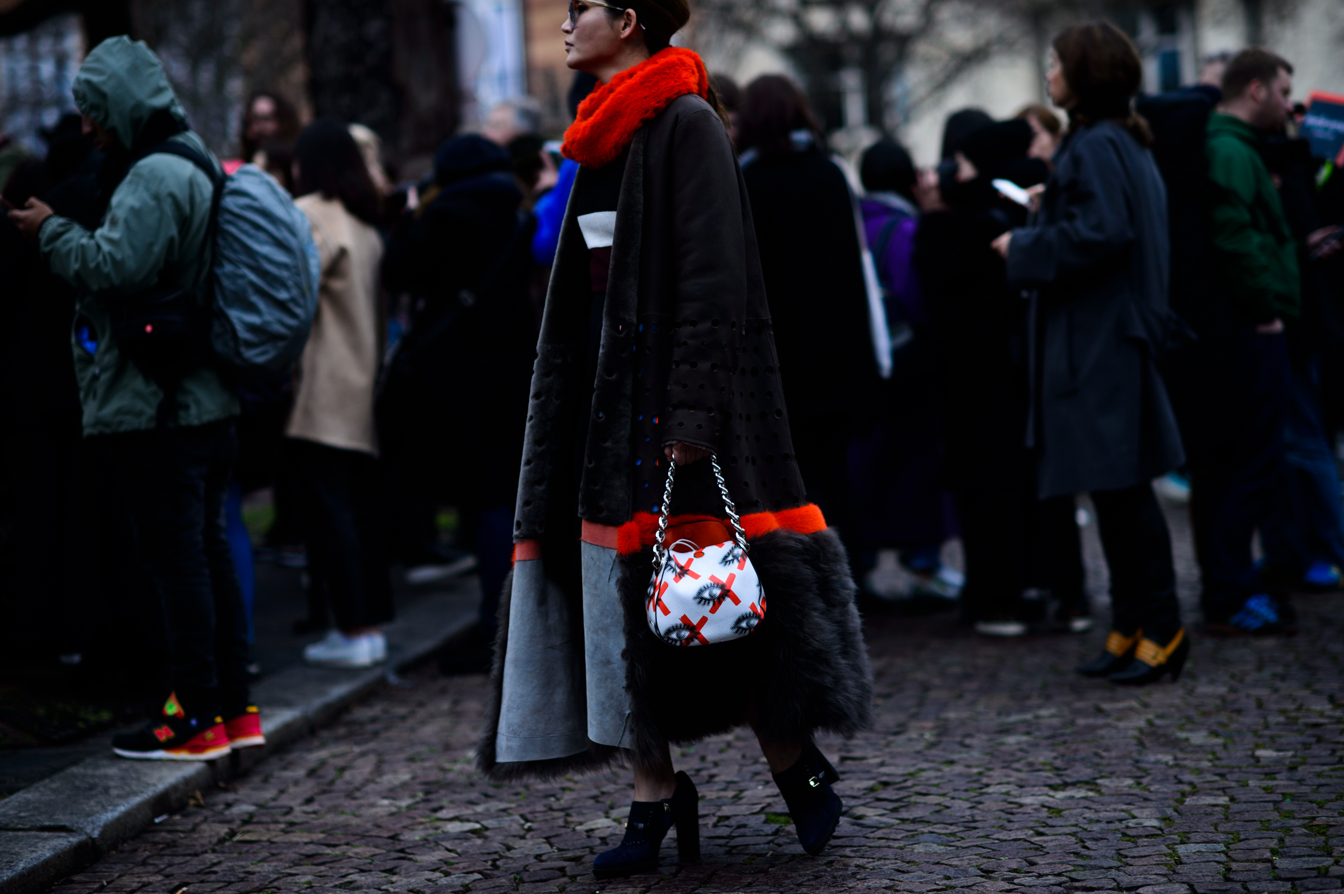 Woman looking into crowd wearing orange and black fur
