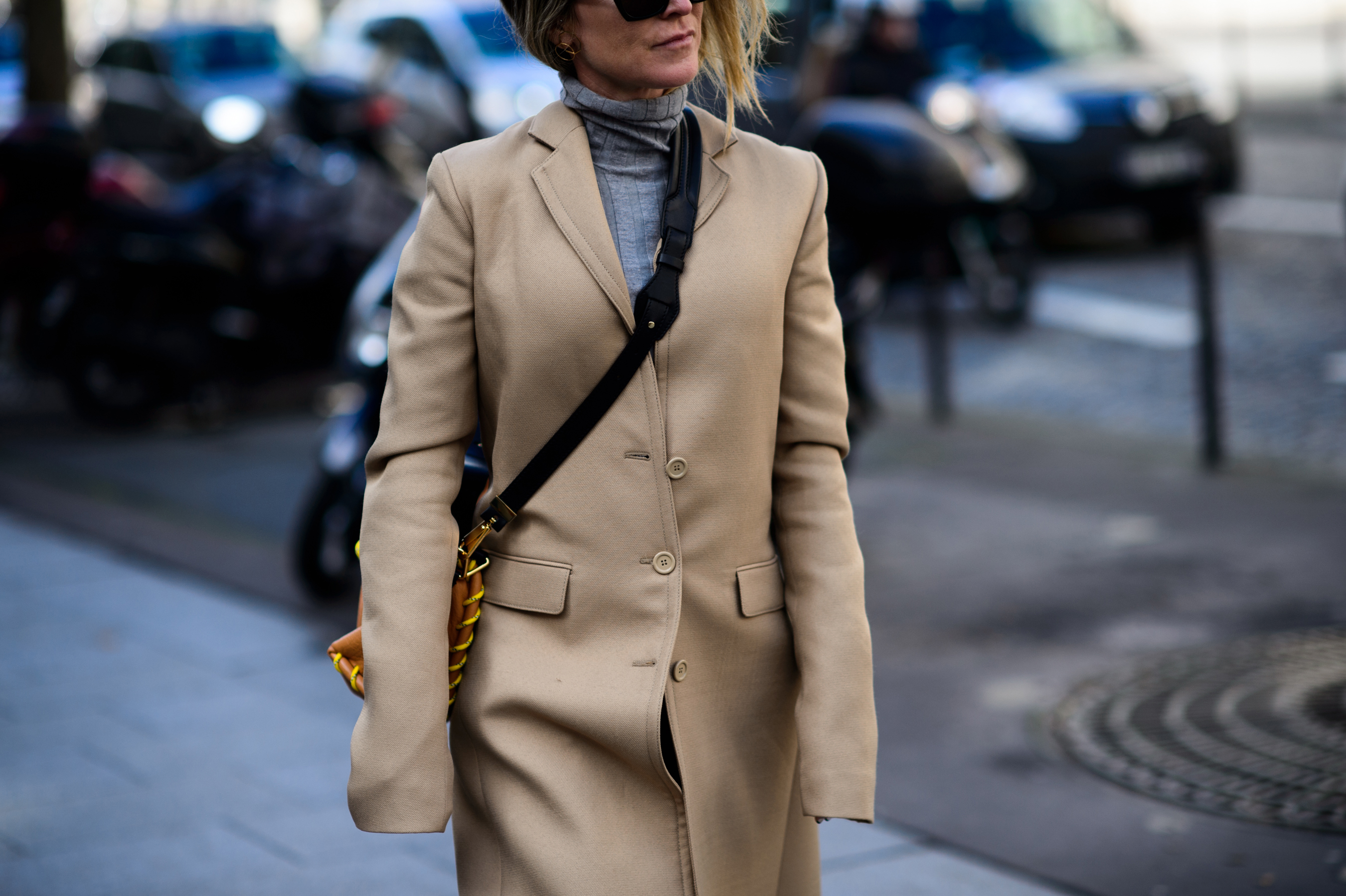 Woman in grey roll neck and camel trench