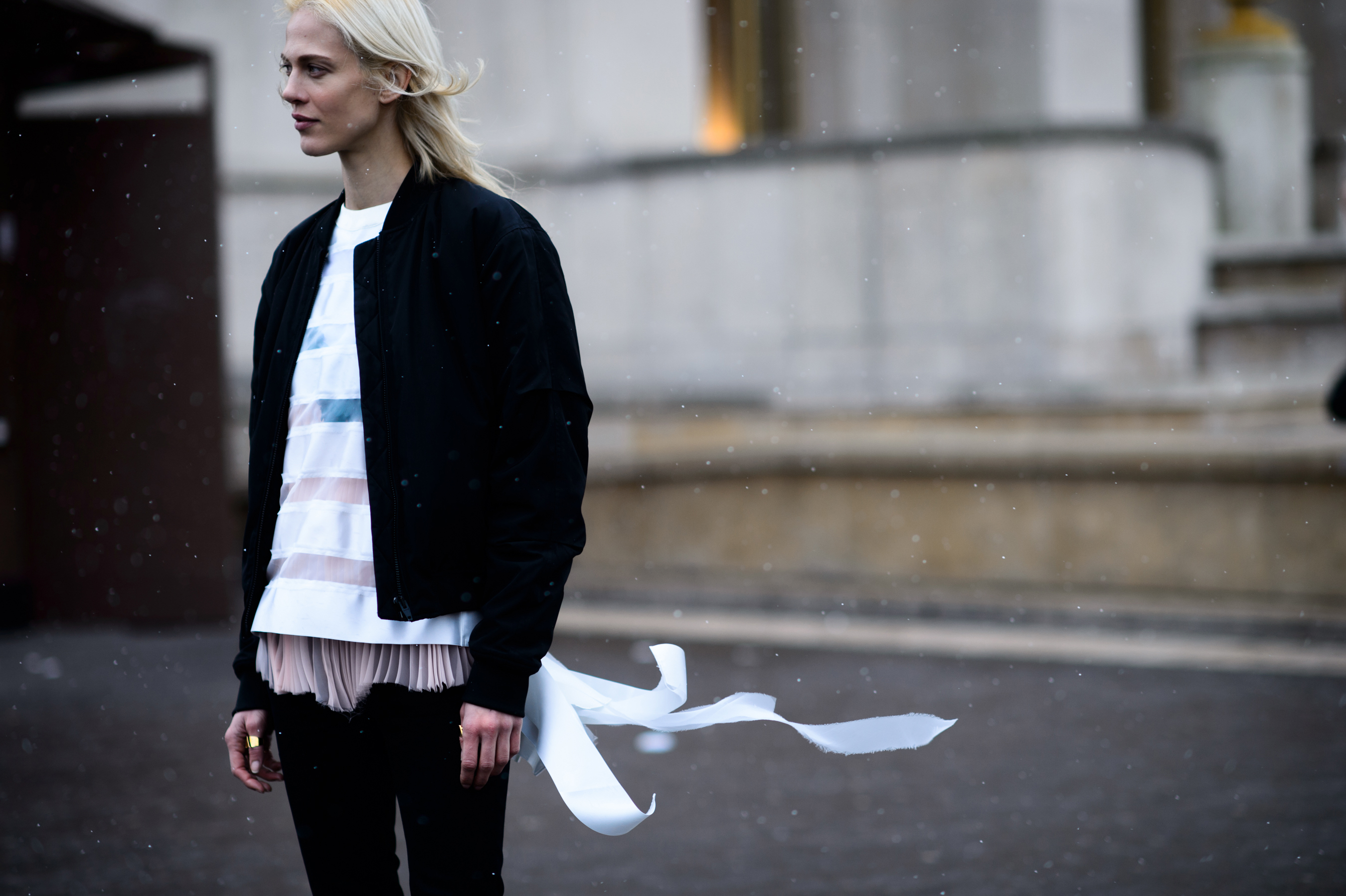 French model stood in snow with clothes blowing in wind