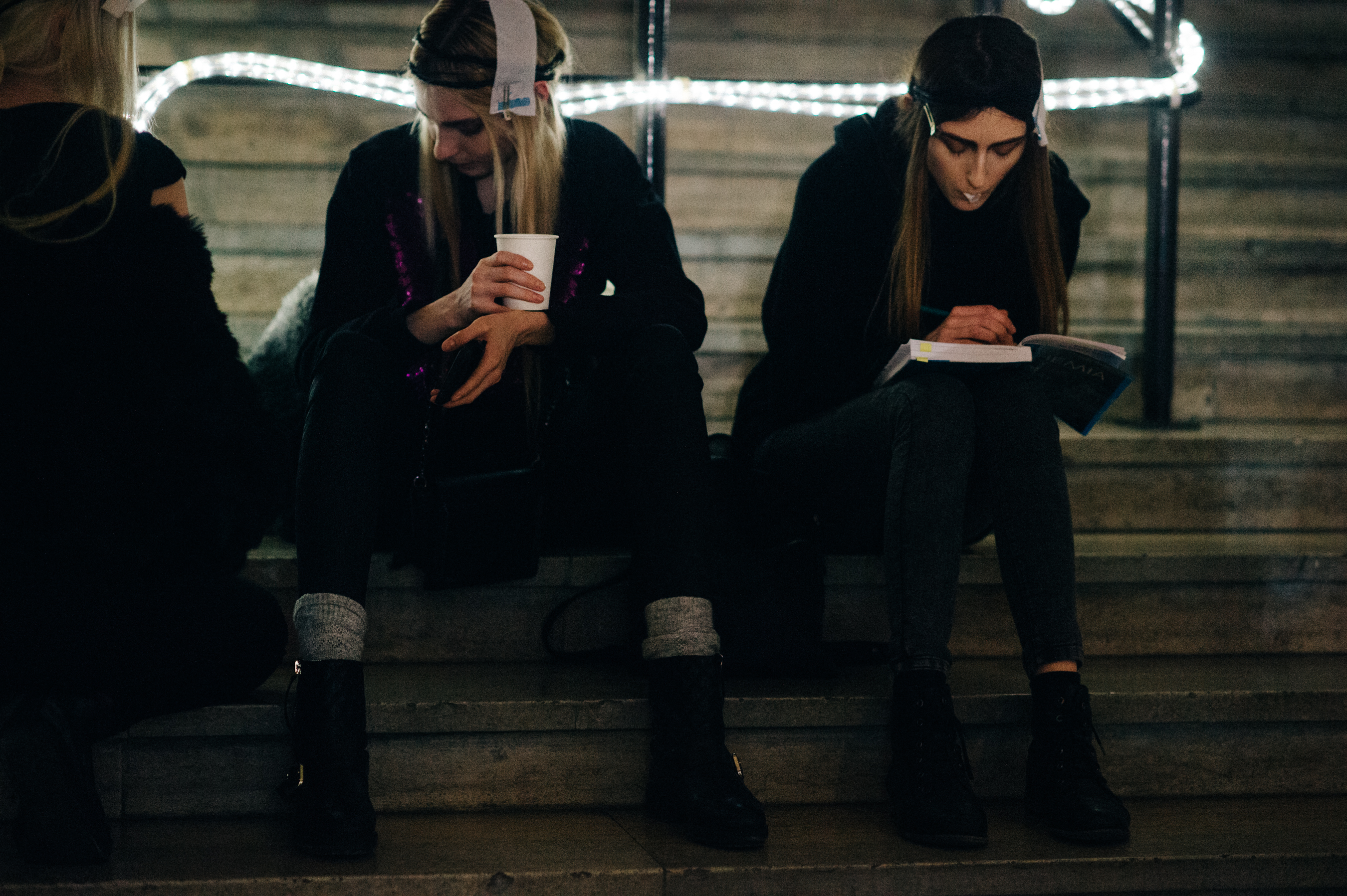 Models drinking and reading on stairs