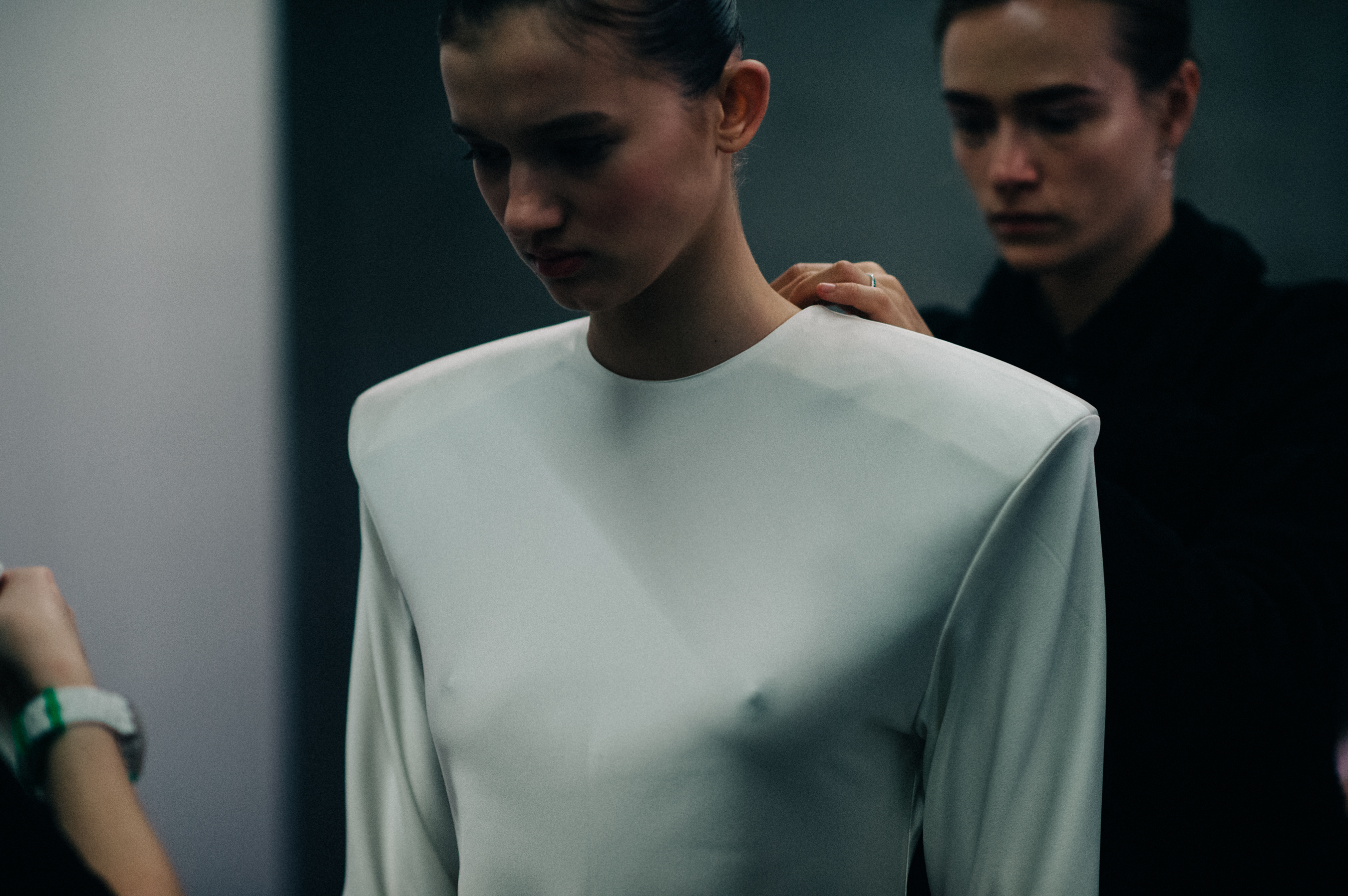 Model getting dressed in white outfit