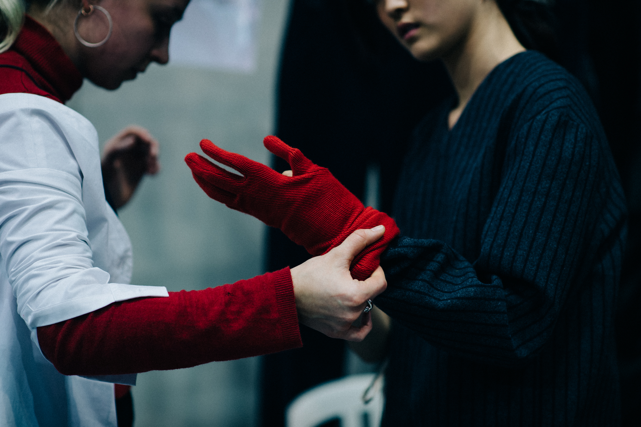 Model trying on red glove before show