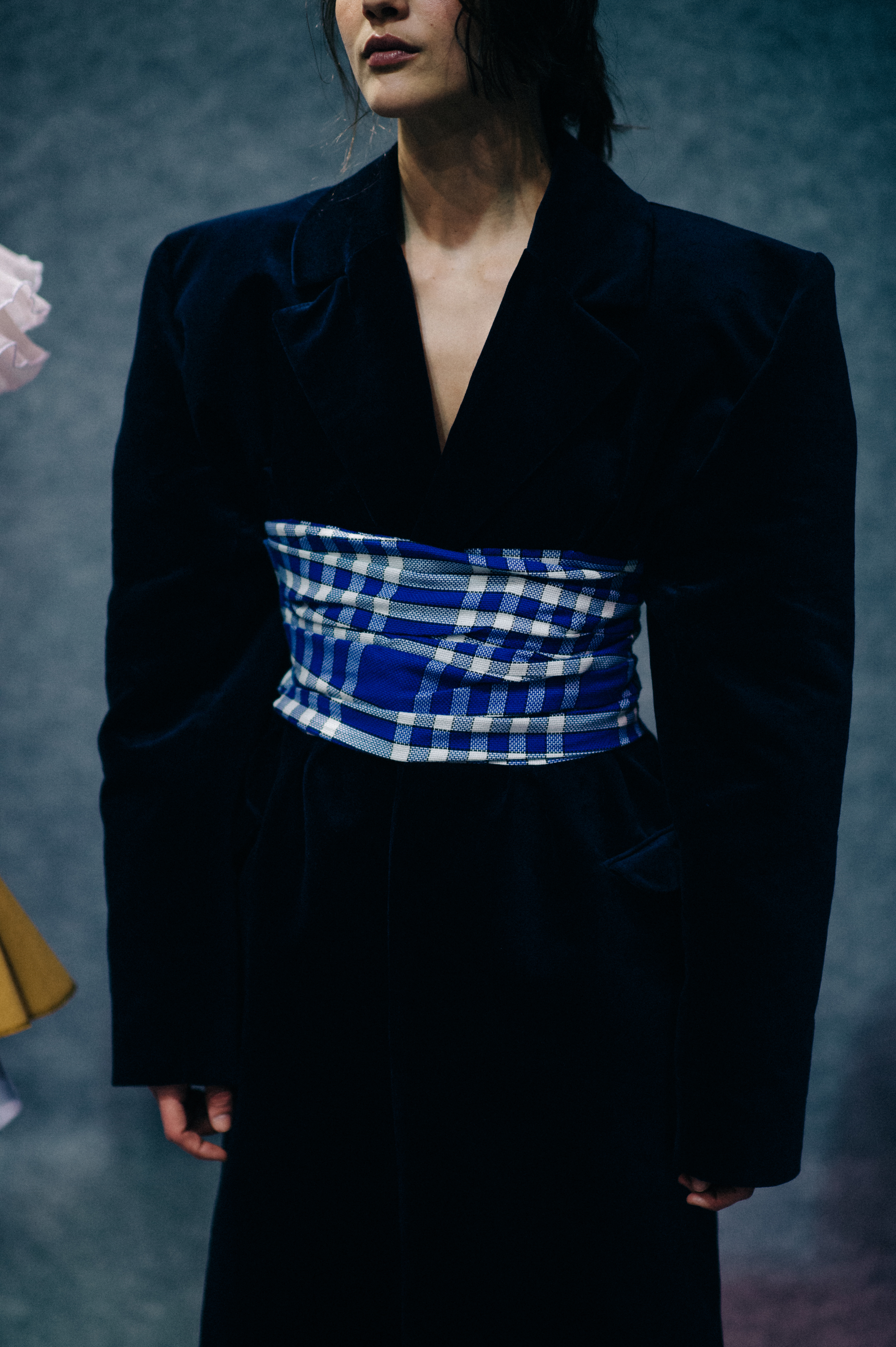 Model wearing jacket and blue waistband