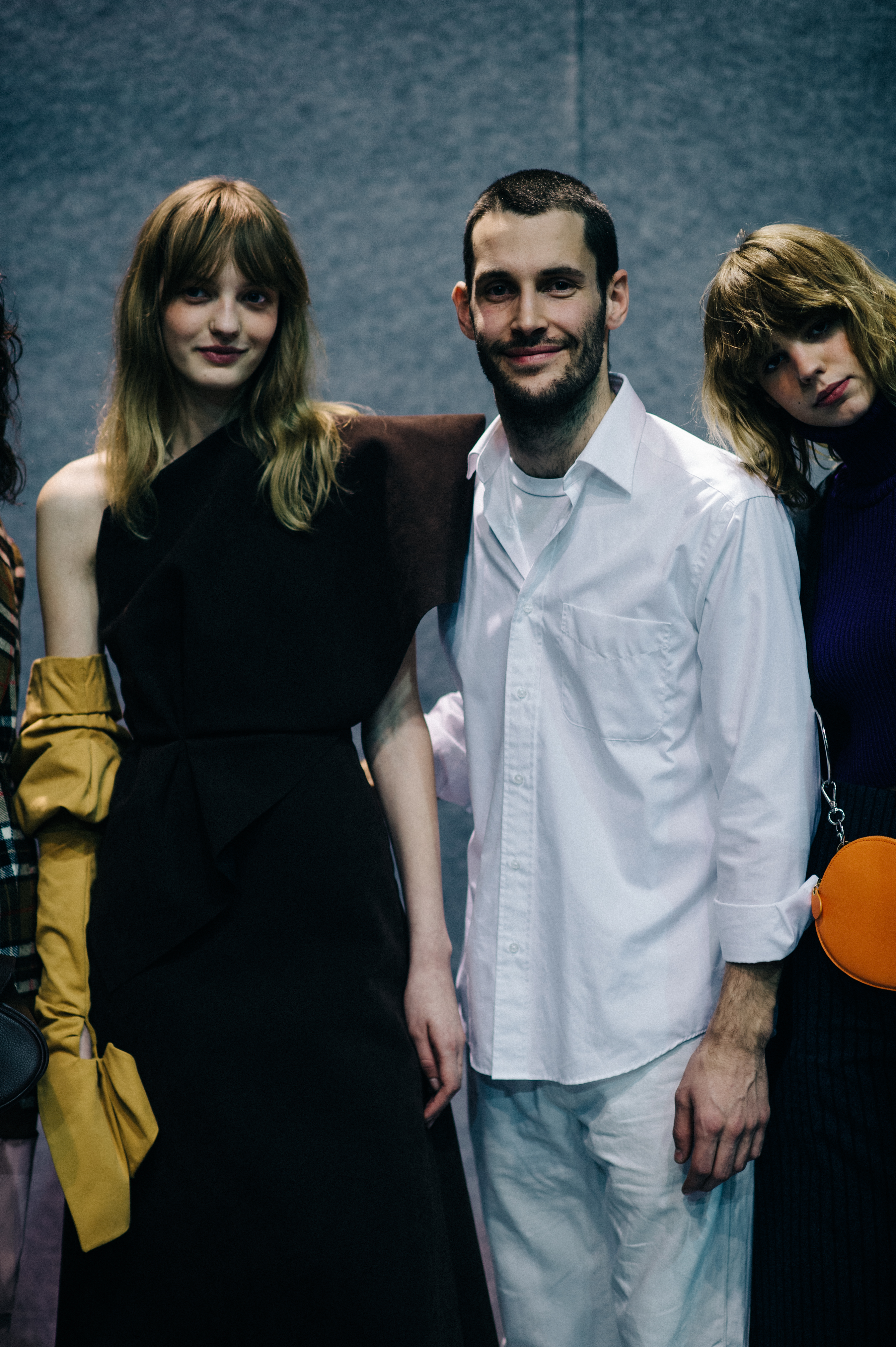 Designer poses with two models