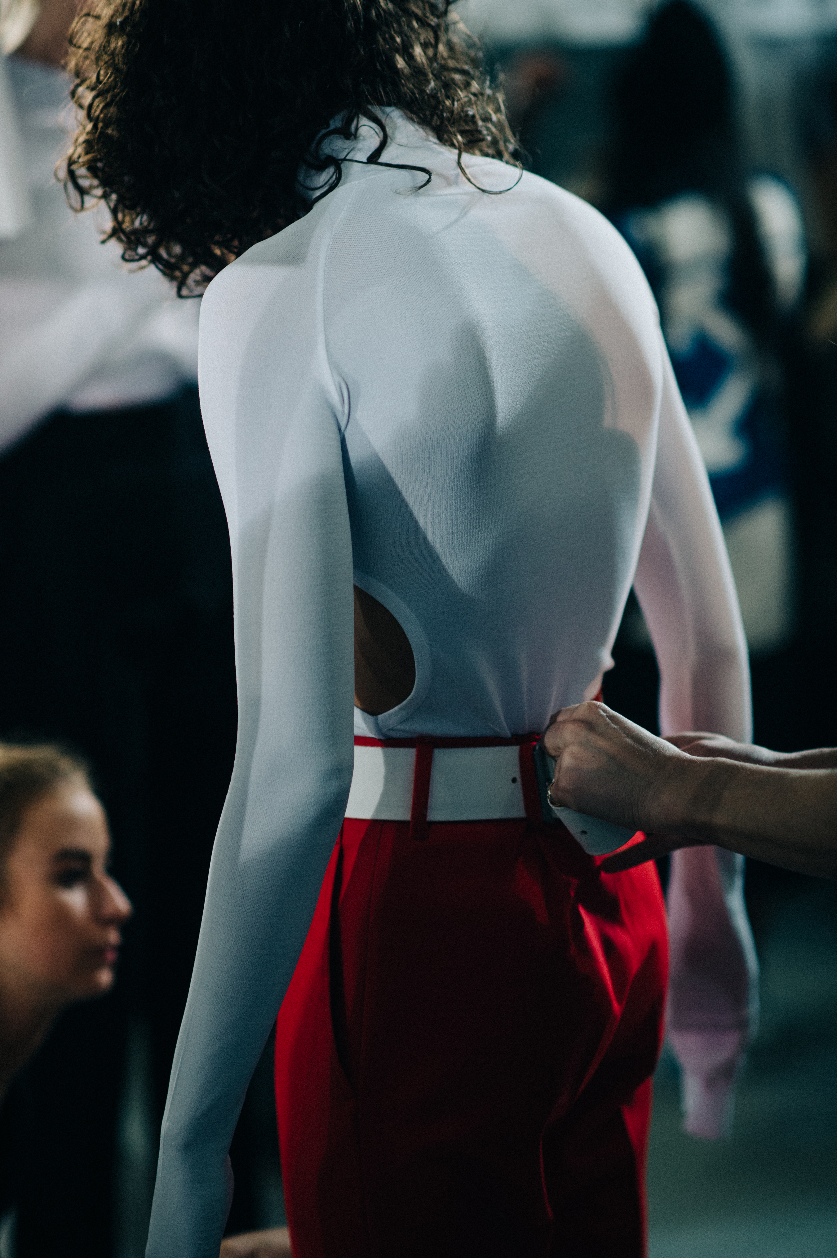 Model wearing white top red pants