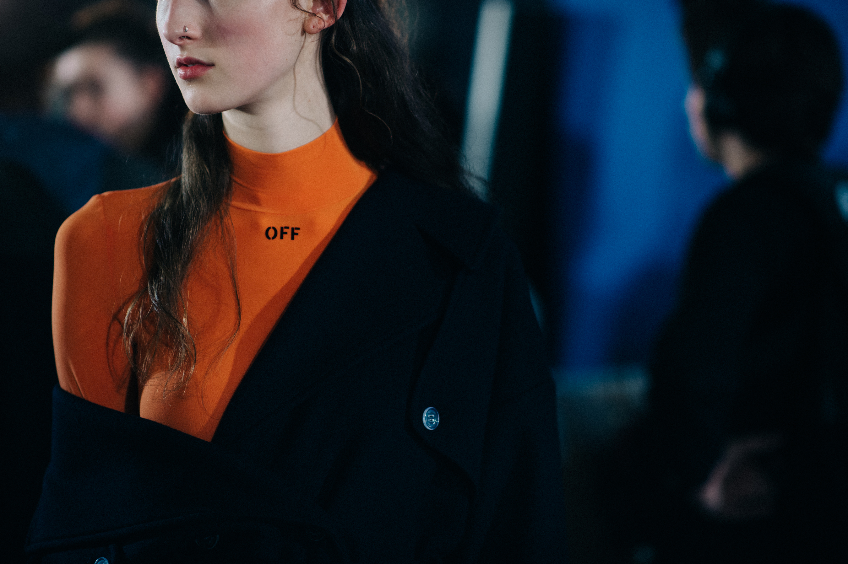 Model wearing orange with nose ring