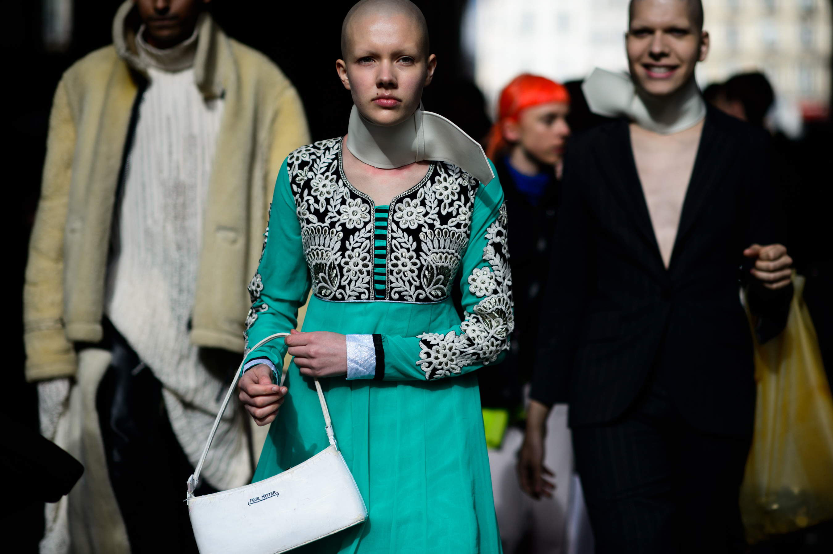 Woman with shaved head in turquoise dress