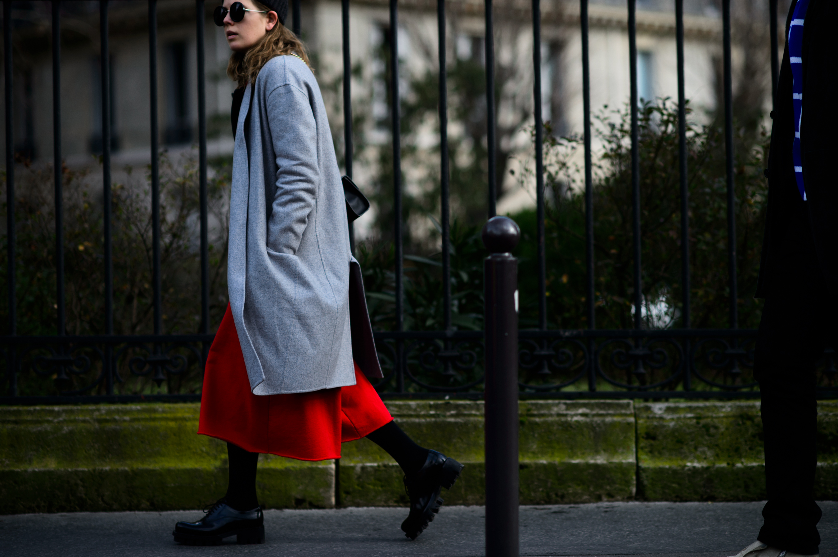 Woman wearing red skirt and grey coat