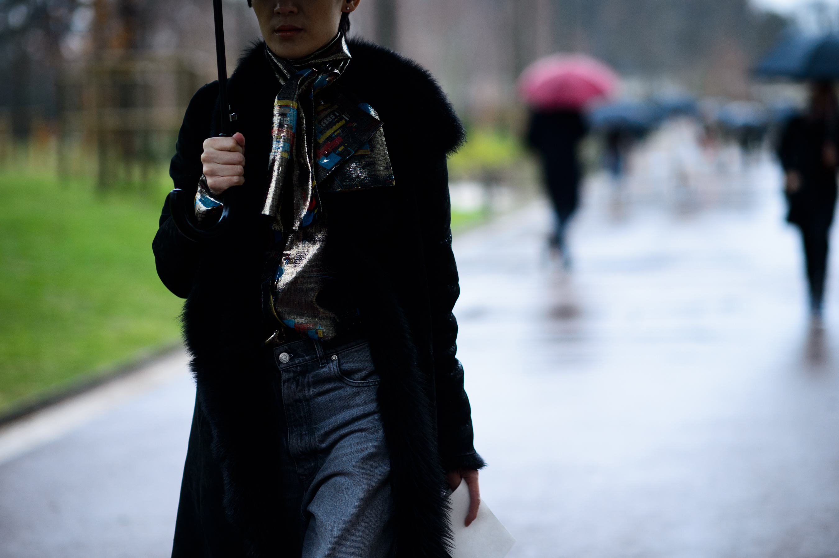 Man holding umbrella over fur hooded coat
