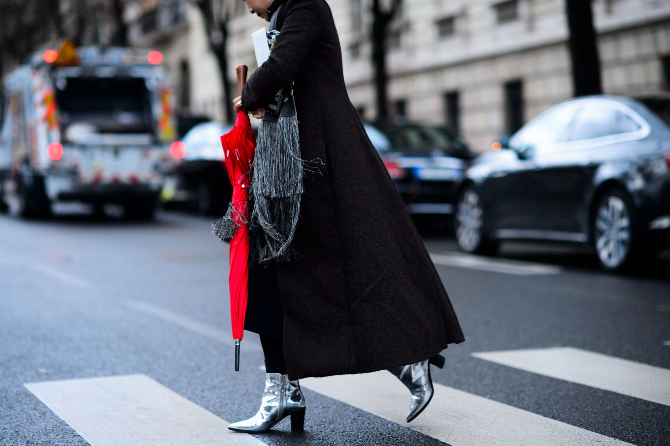 Woman crossing road with red umbrella