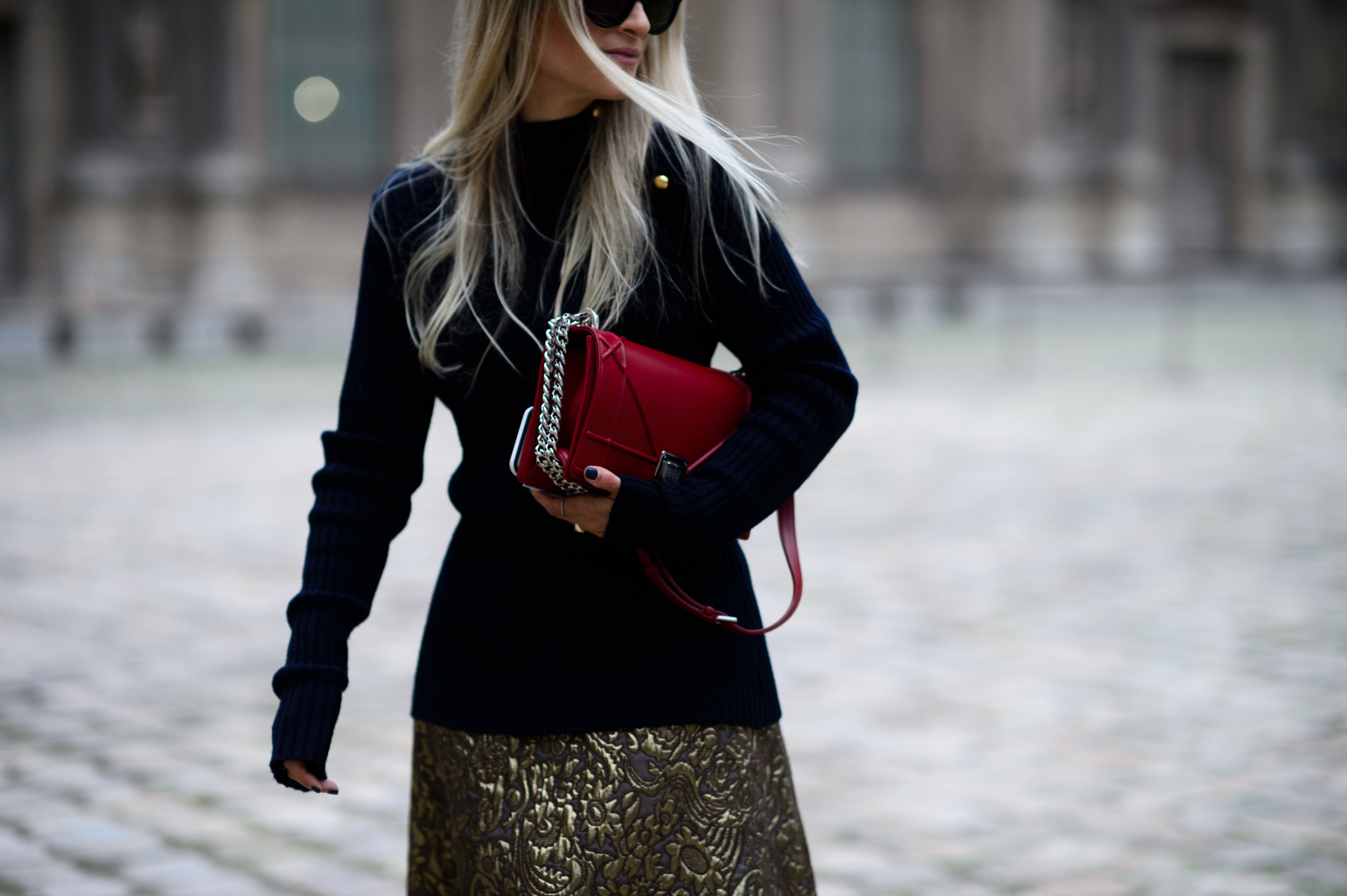 Woman holding red bag with blonde hair